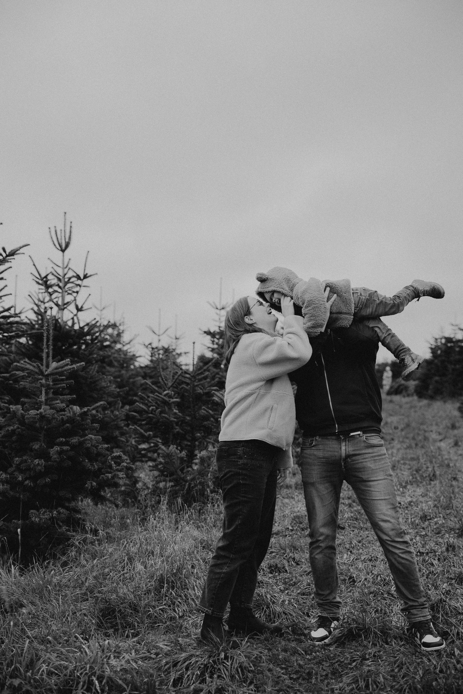 A sequence of black and white photos showing two people playfully wrestling or fighting in a grassy field.