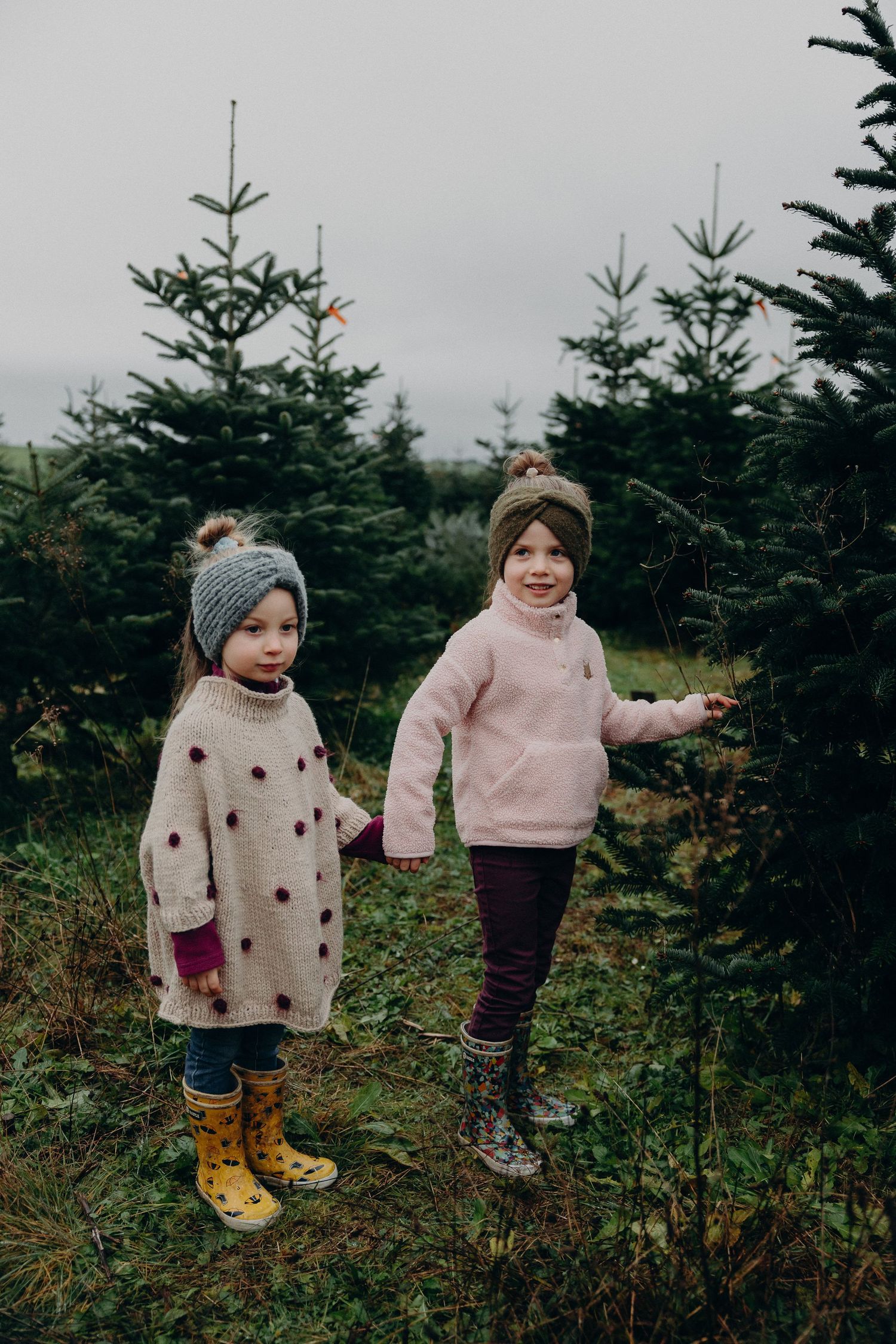 A sequence of five photos showing two children exploring an evergreen tree farm on a moody autumn day.