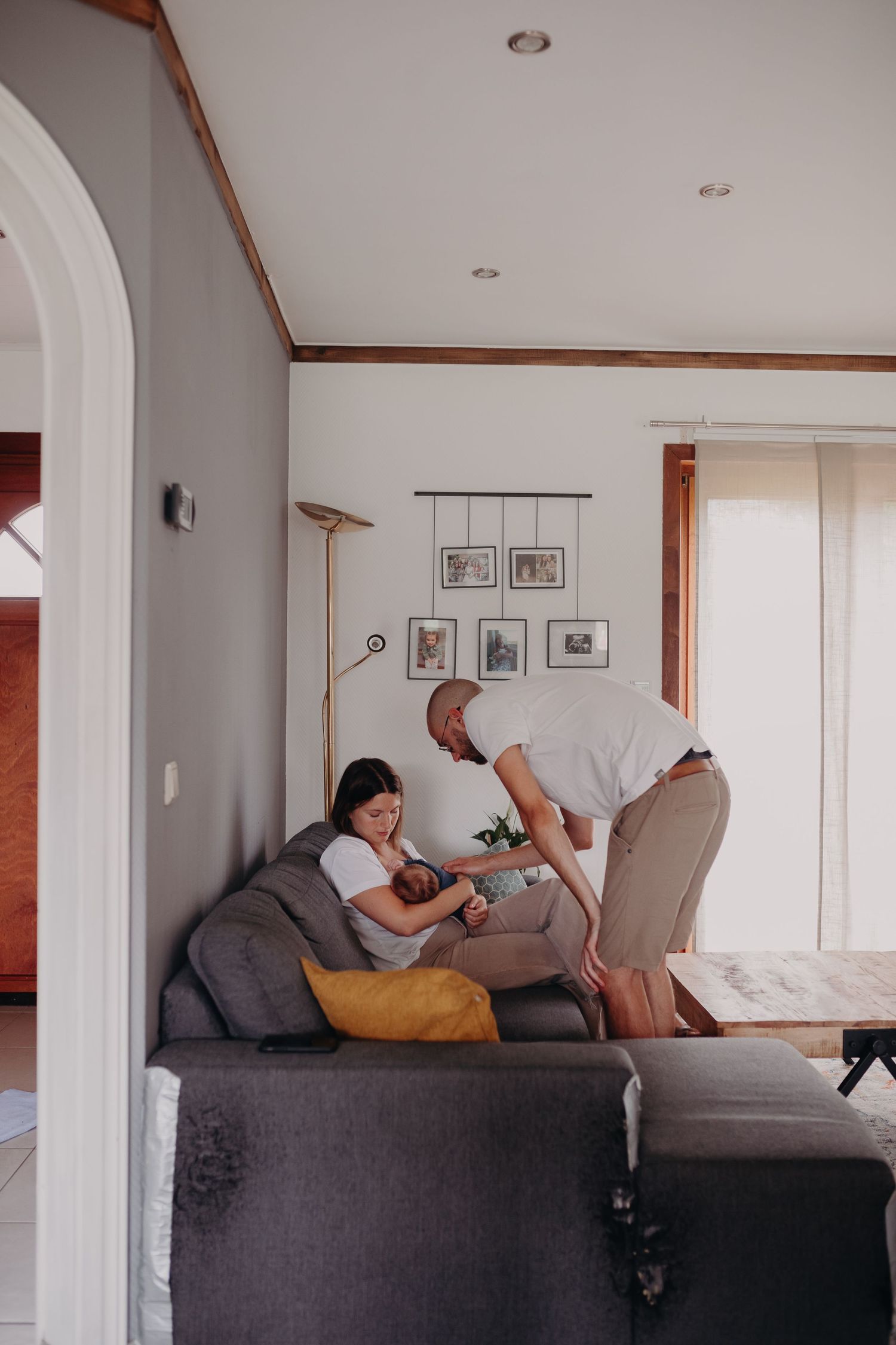A series of four photos showing a couple relaxing and cuddling together on a gray couch in a bright, modern living room.