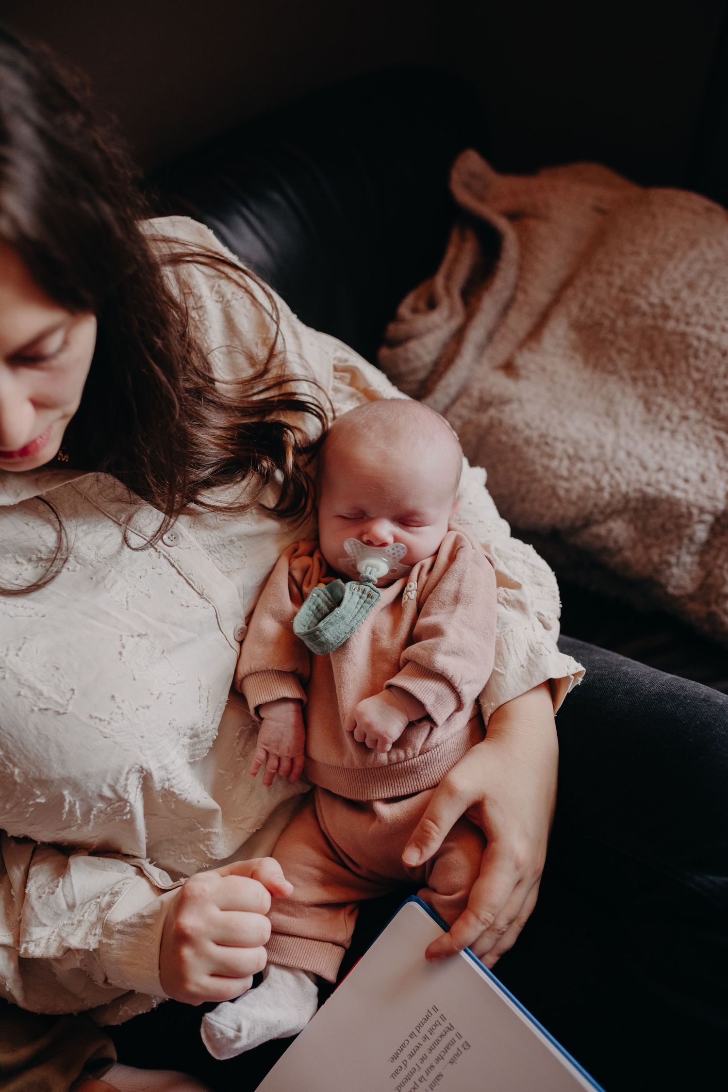 Family reading together on couch while sharing intimate bonding moments over a children's book.
