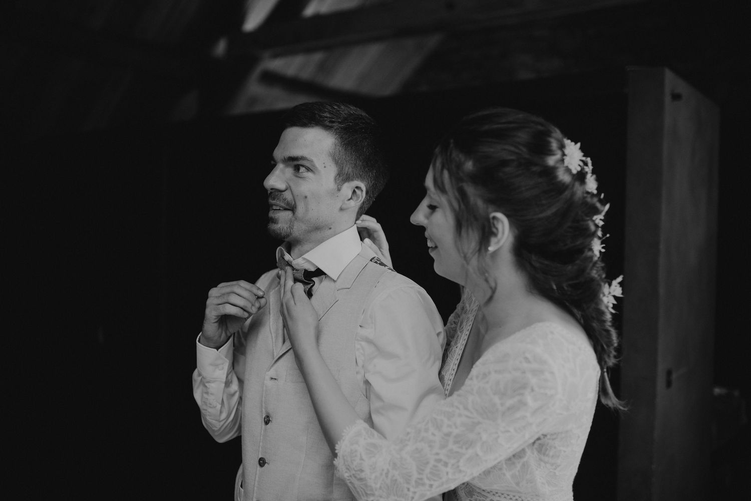 A black and white wedding photo captures a couple in elegant attire preparing for their ceremony.