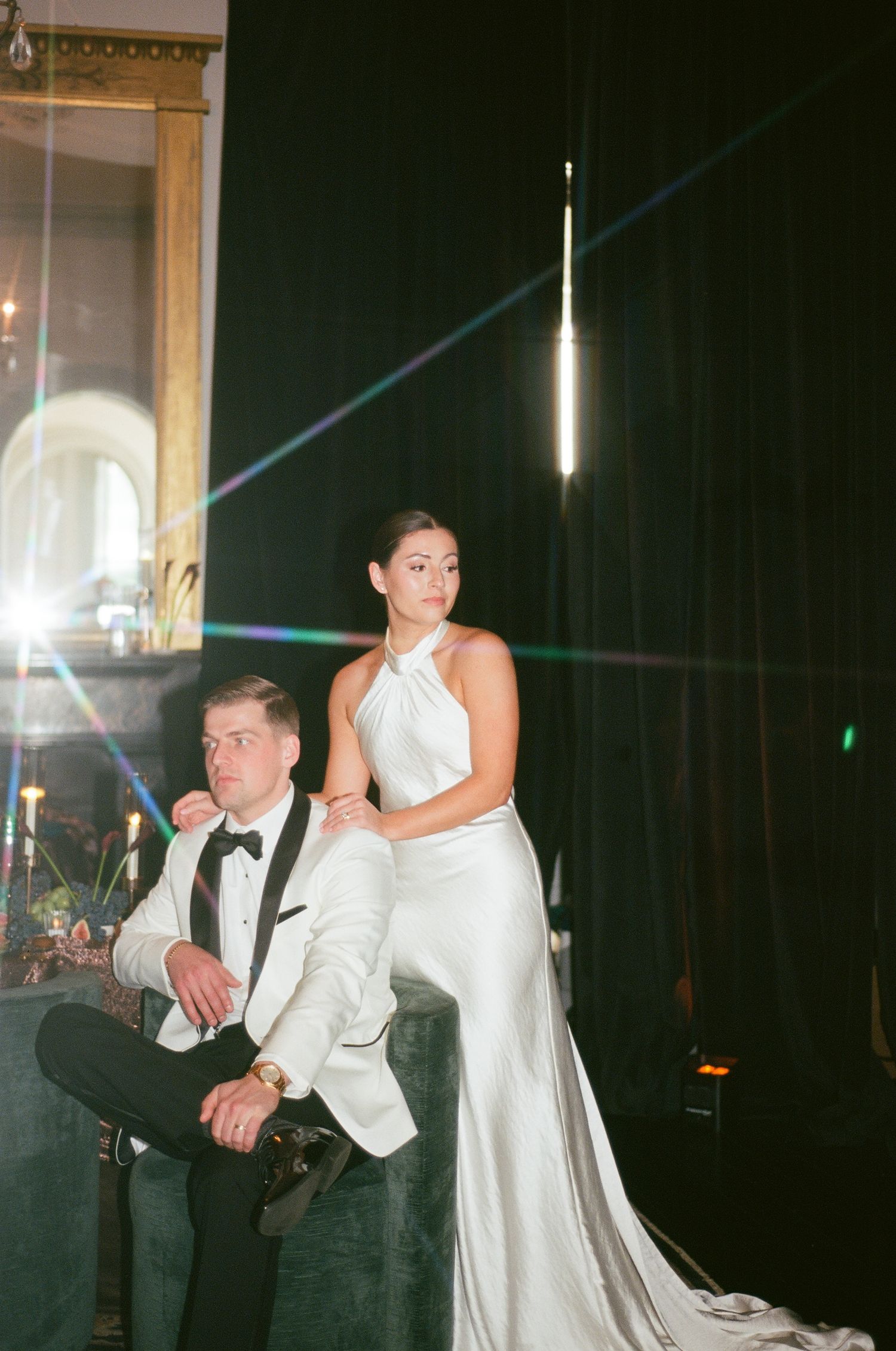 Bride in a flowing gown sharing a tender embrace in a softly lit reception setting.