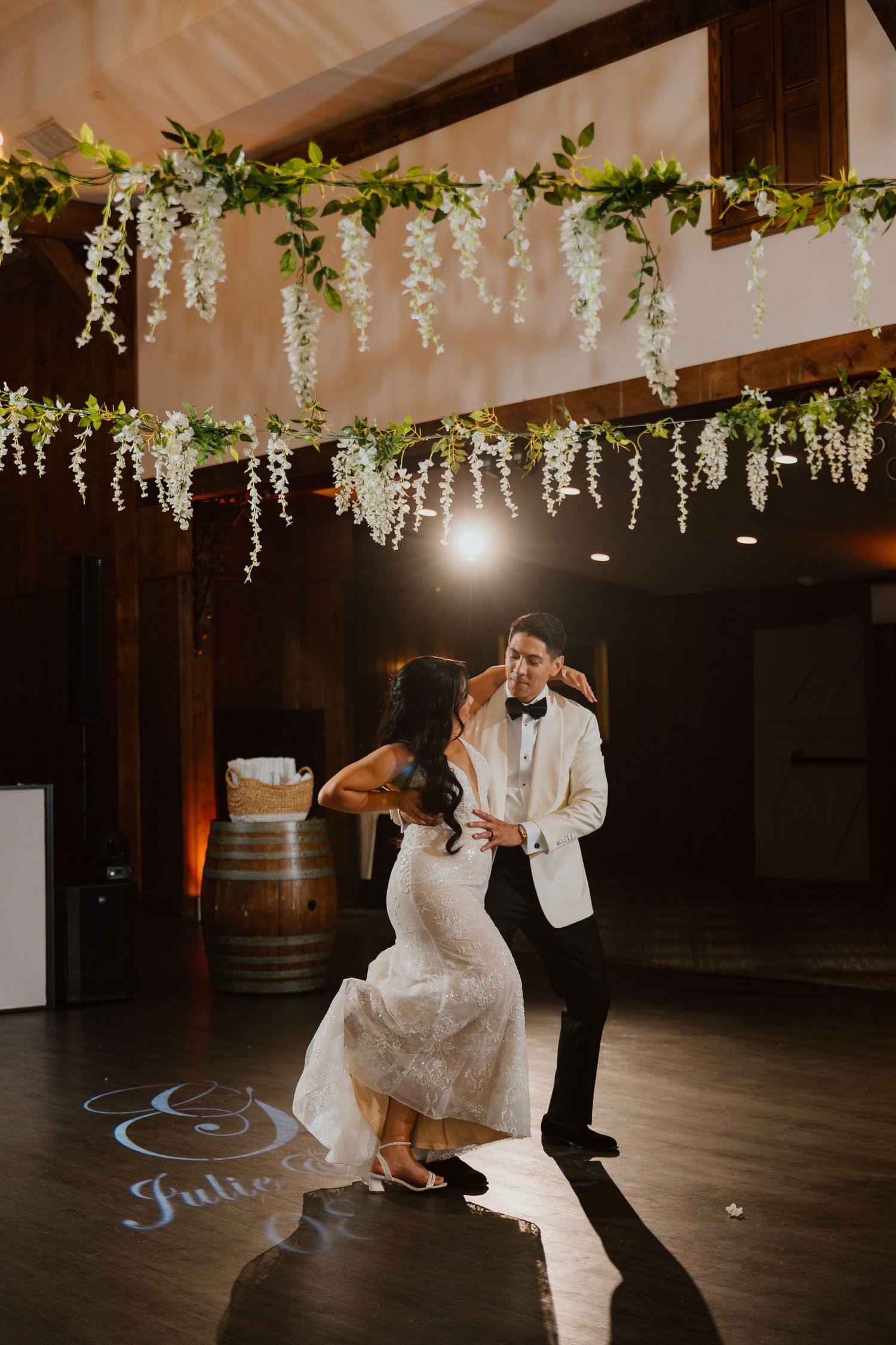 Bride and groom sharing an intimate moment under hanging string lights and cascading florals at the reception.