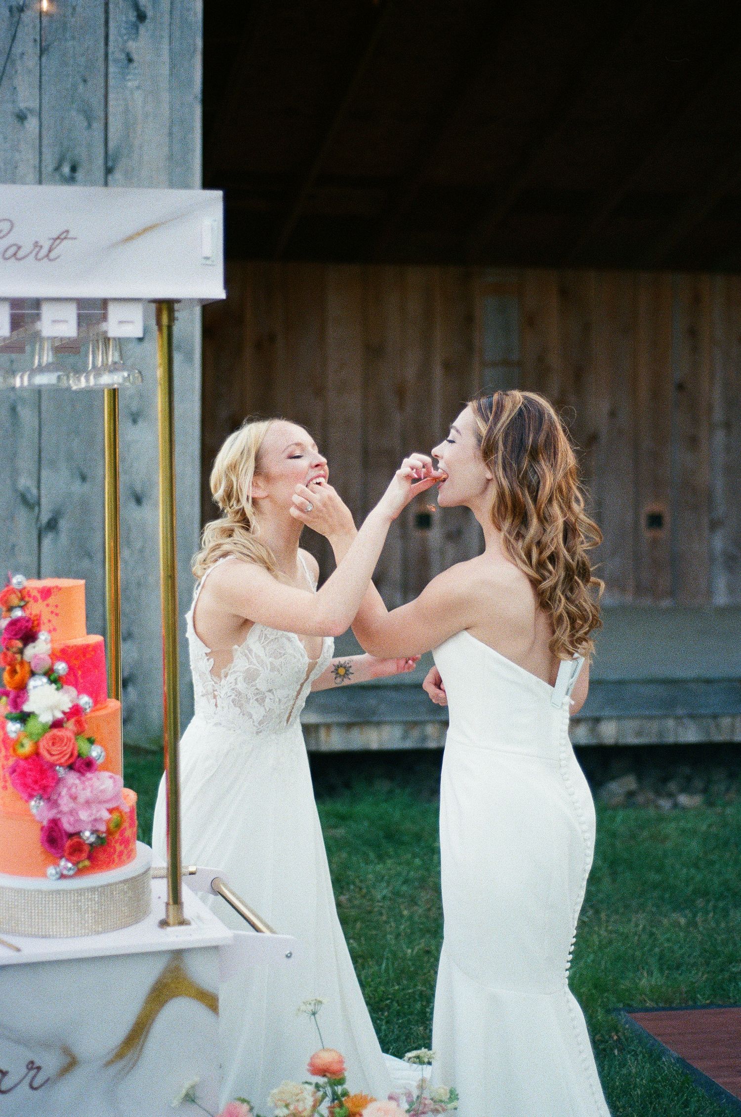 Two brides holding bouquets at an outdoor wedding ceremony.