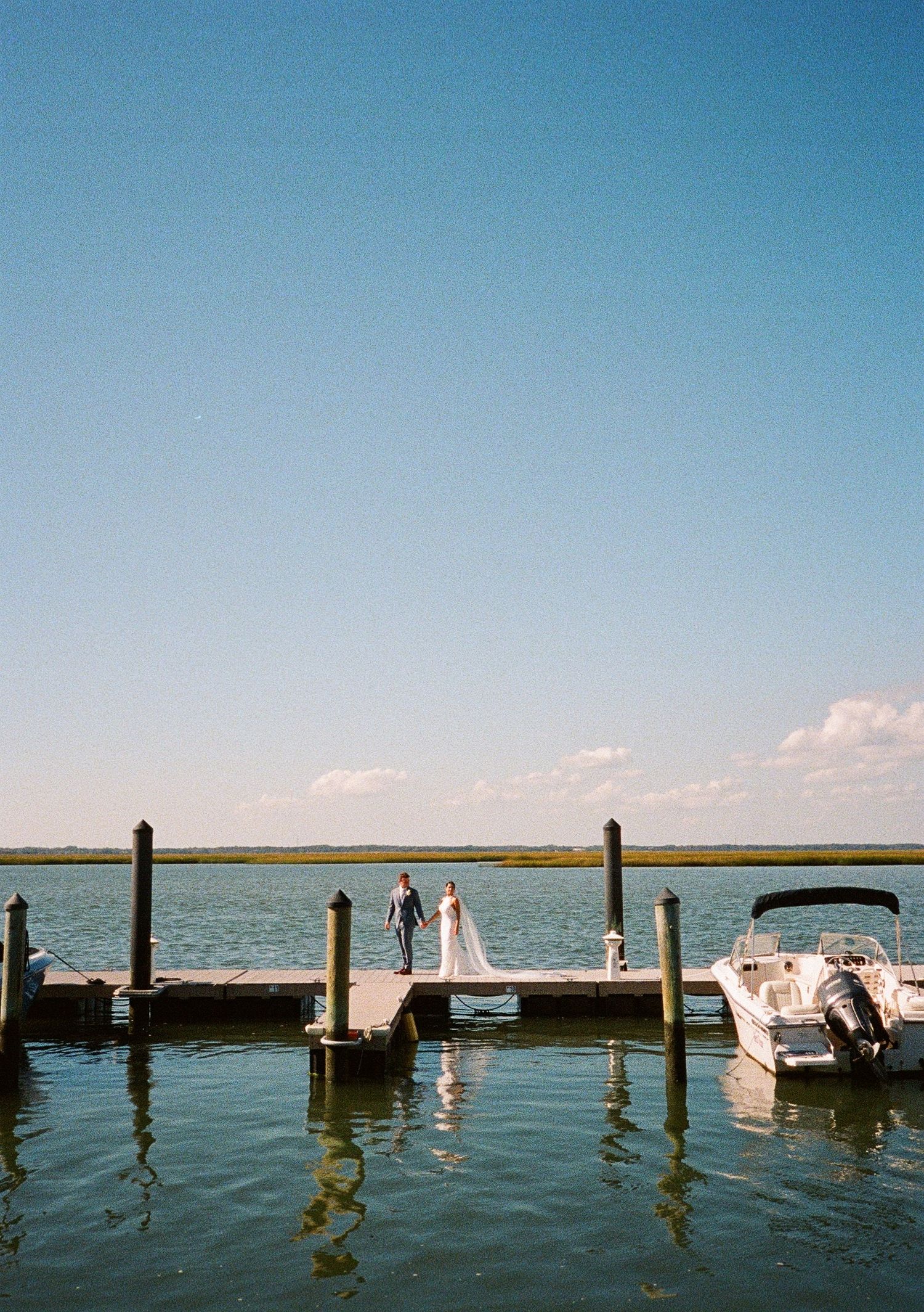 Wooden dock stretching over calm water at a waterfront wedding venue.