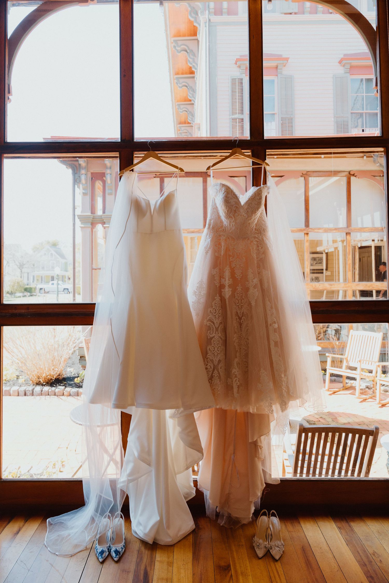 Wedding dress hanging in a window with natural light at a wedding venue.