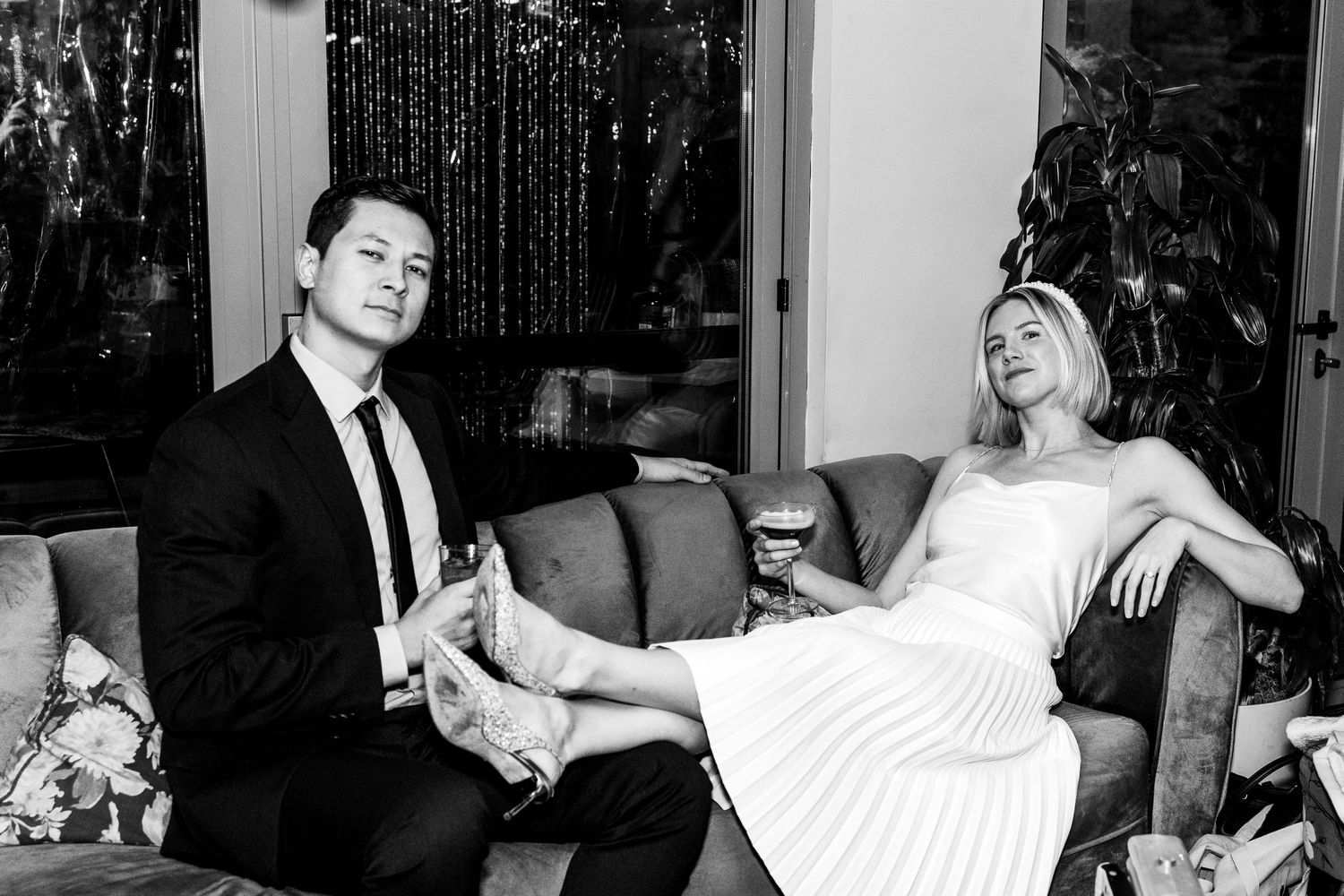 Black and white photo of a couple lounging on a vintage sofa.