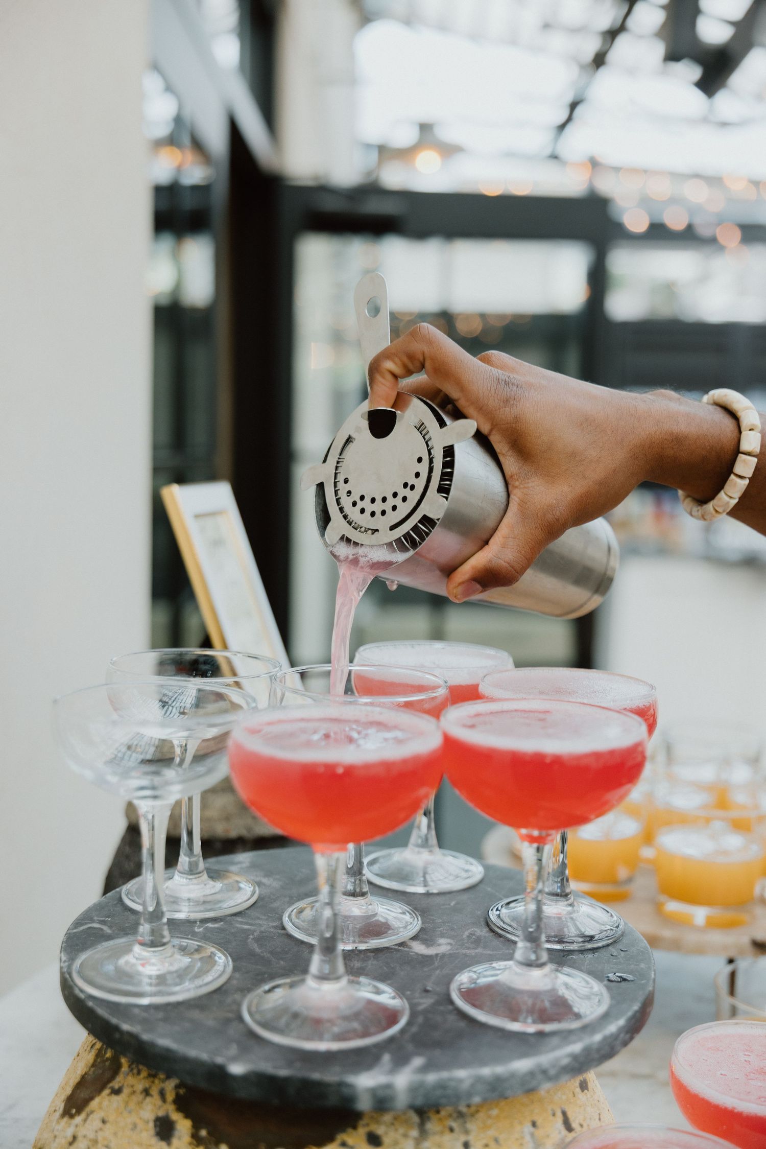 Champagne poured into coupe glasses at a wedding cocktail reception.