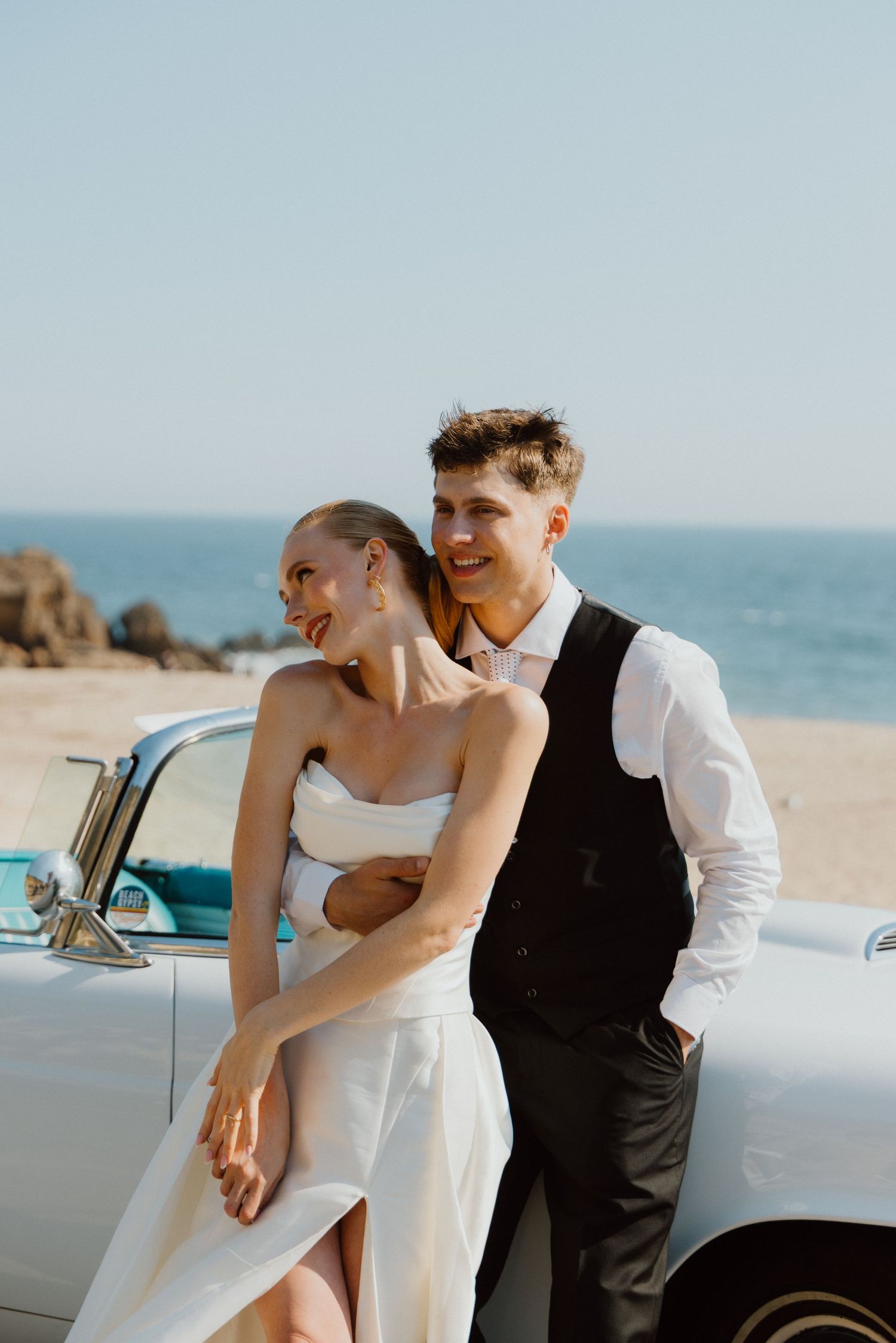 Bride and groom embracing on the beach during an oceanfront elopement.