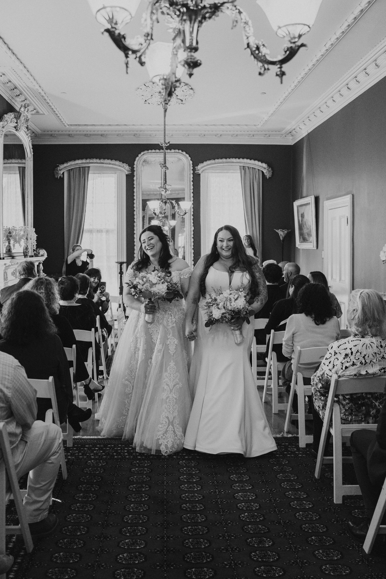 Black and white photo of a bride in an elegant indoor wedding venue.