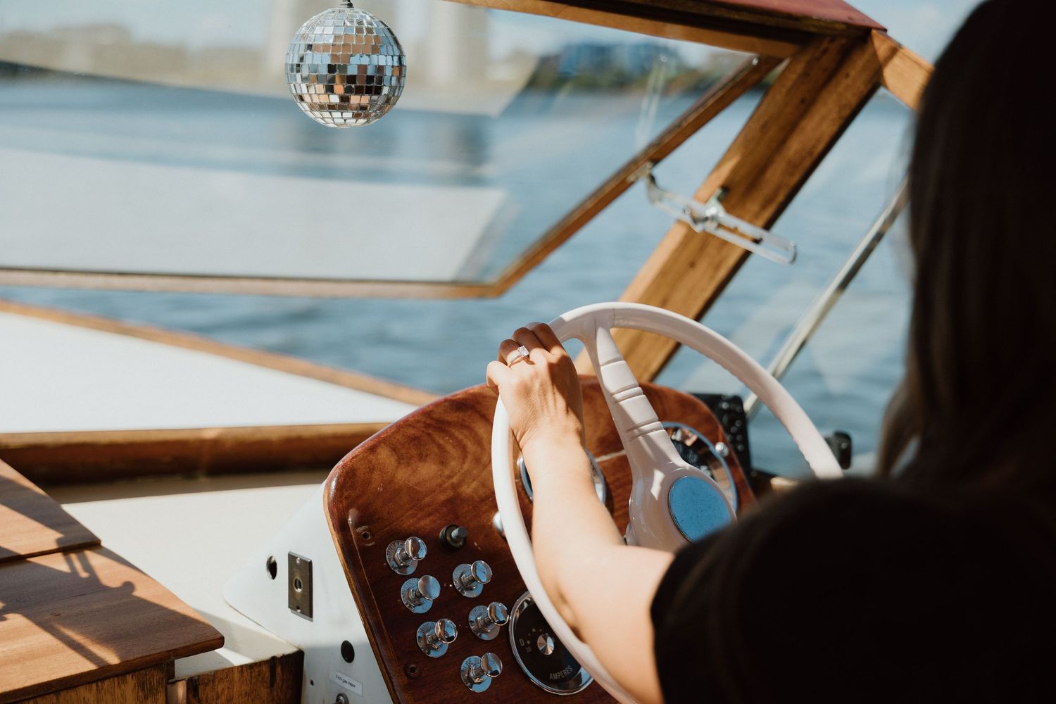Vintage boat interior detail with a hanging disco ball seen through the cabin window.