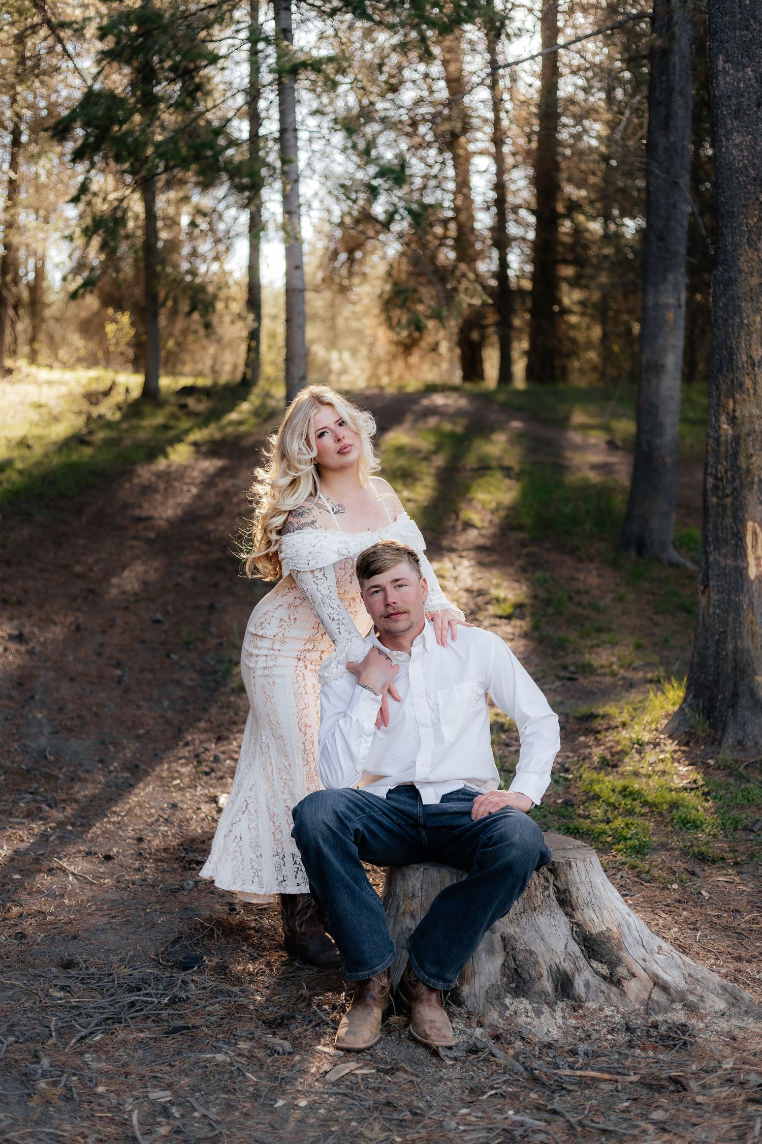 a western couple posing in a forest close to Rexburg Idaho posing for their engagement pictures for their wedding island park.