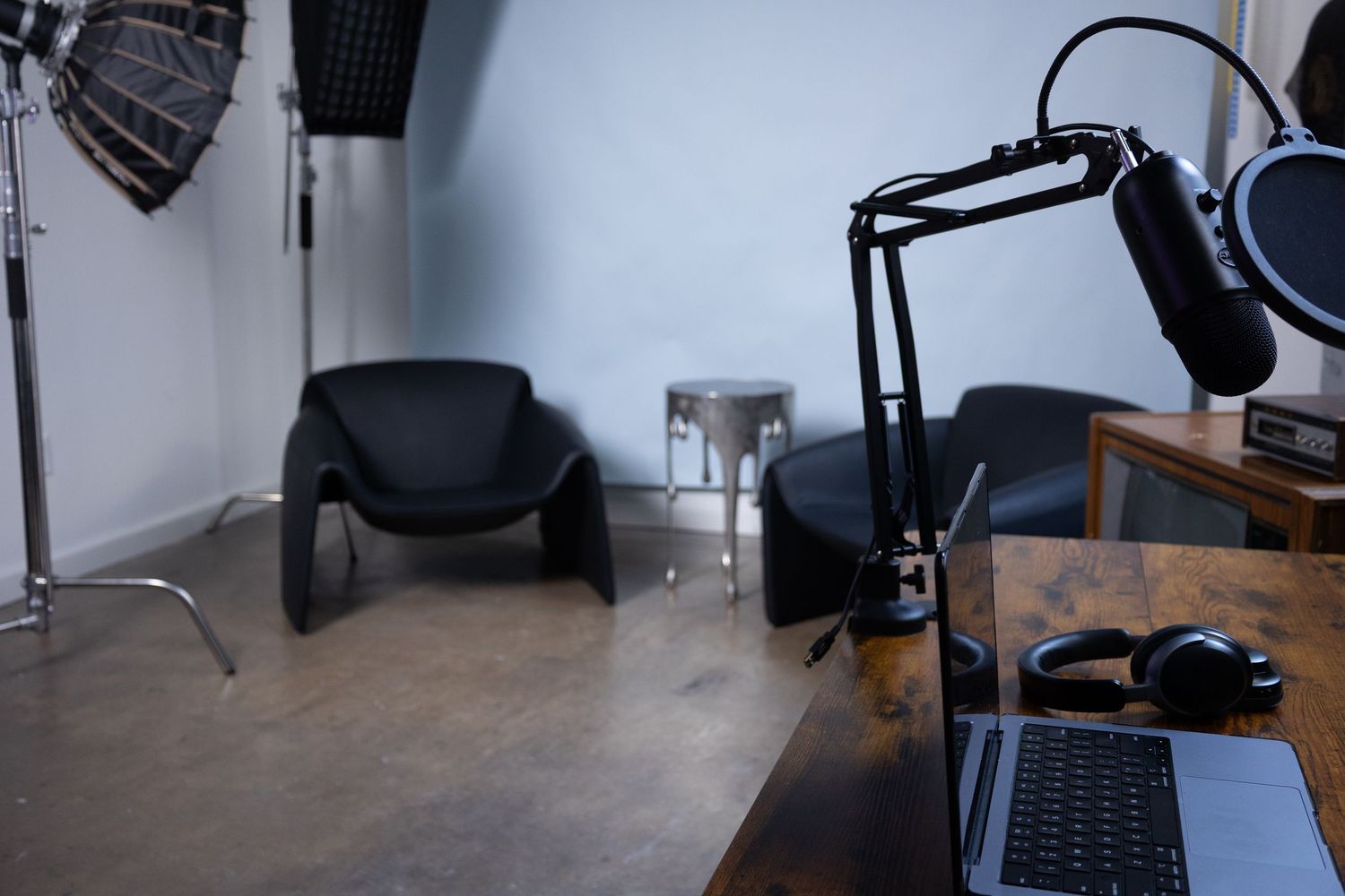 Podcast recording setup in studio with microphone, headphones, and workspace for creators