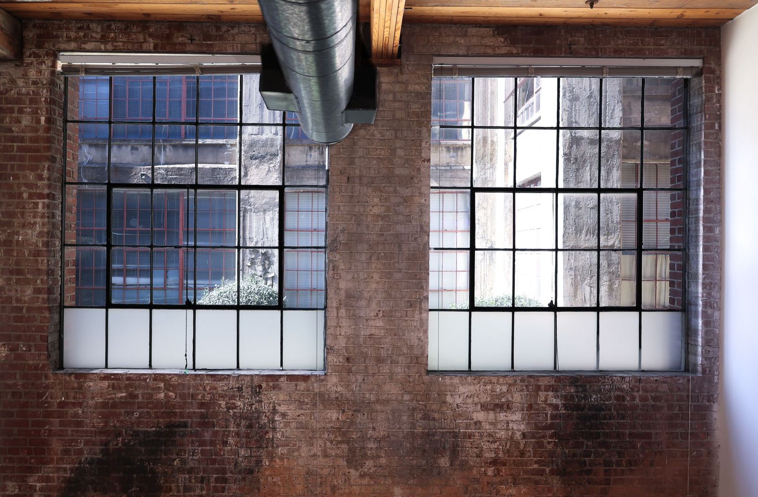 Industrial loft studio with large grid windows and natural light for photography and video shoots
