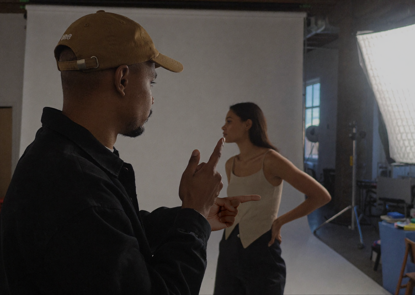 Photographer directing model during fashion photoshoot inside professional photography studio rental