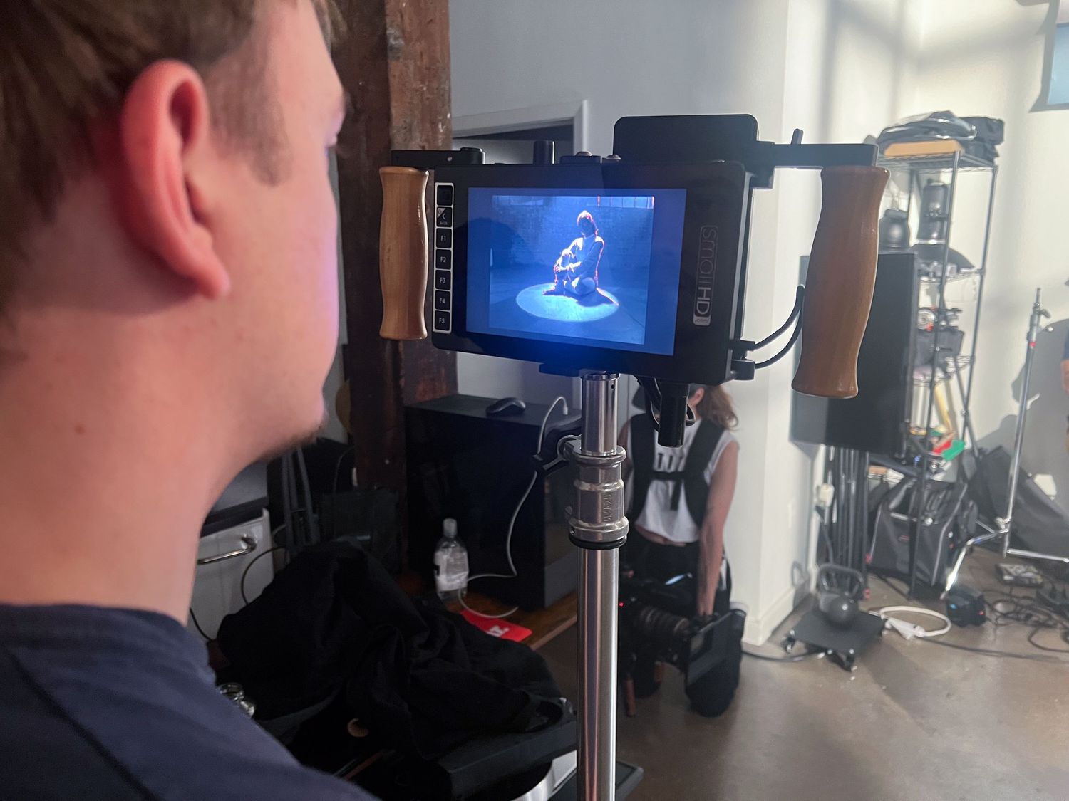 Behind the scenes video production setup in studio with camera monitor and lighting equipment