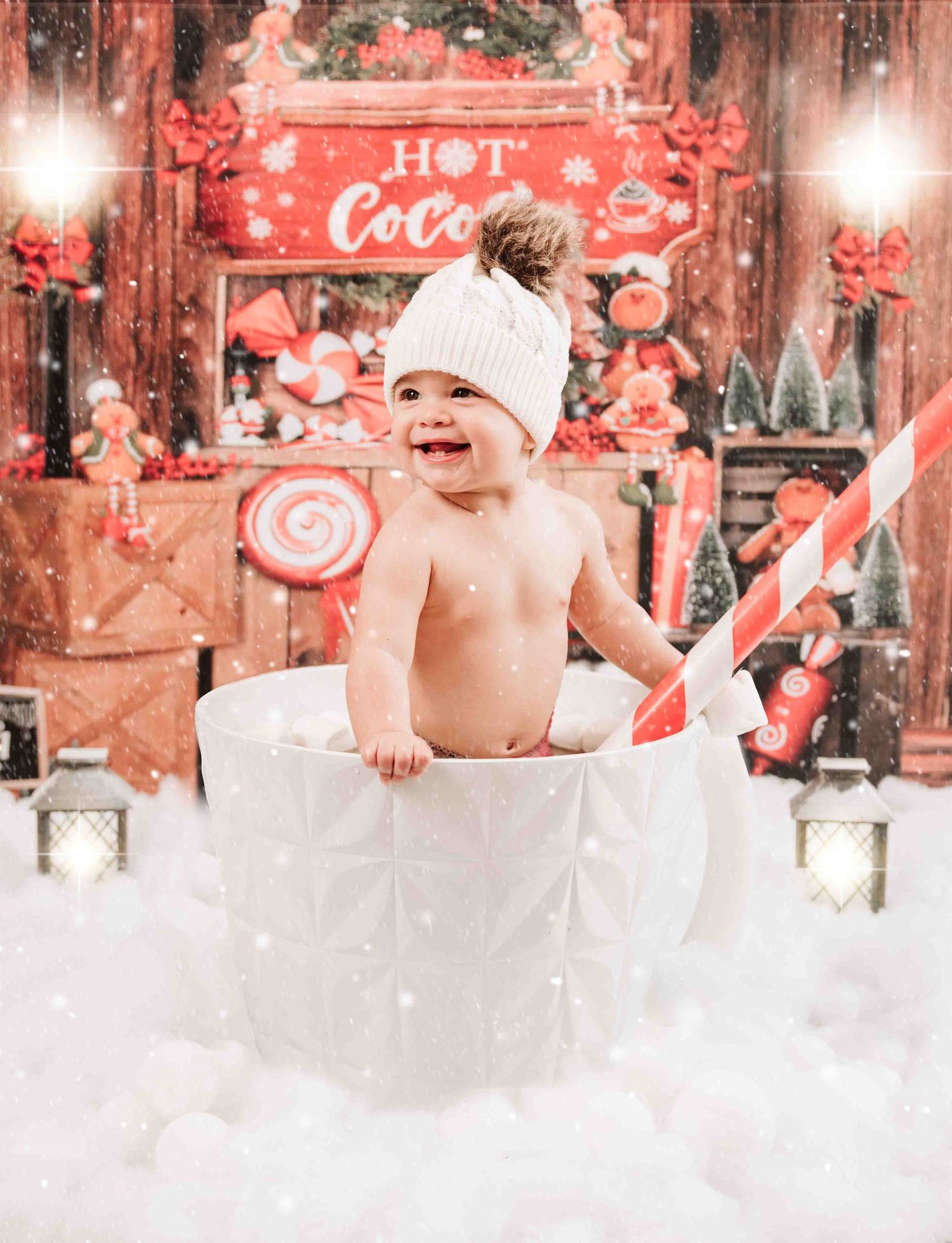 Baby sits joyfully in a white cup against a festive red holiday backdrop with Coca-Cola decor and snowy effects.