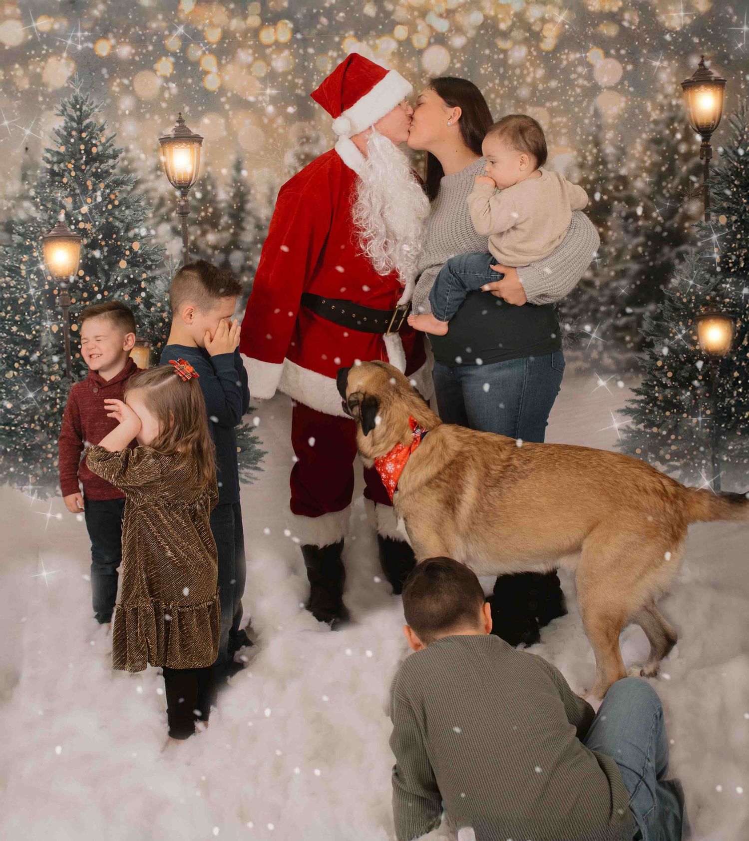 A festive winter scene with Santa Claus, kids, and a golden retriever amid snowy evergreens and glowing lights.