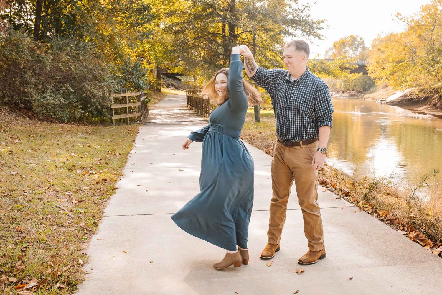 A couple dances along a path dancing to celebrate their pregnancy in Smithfield, NC.
