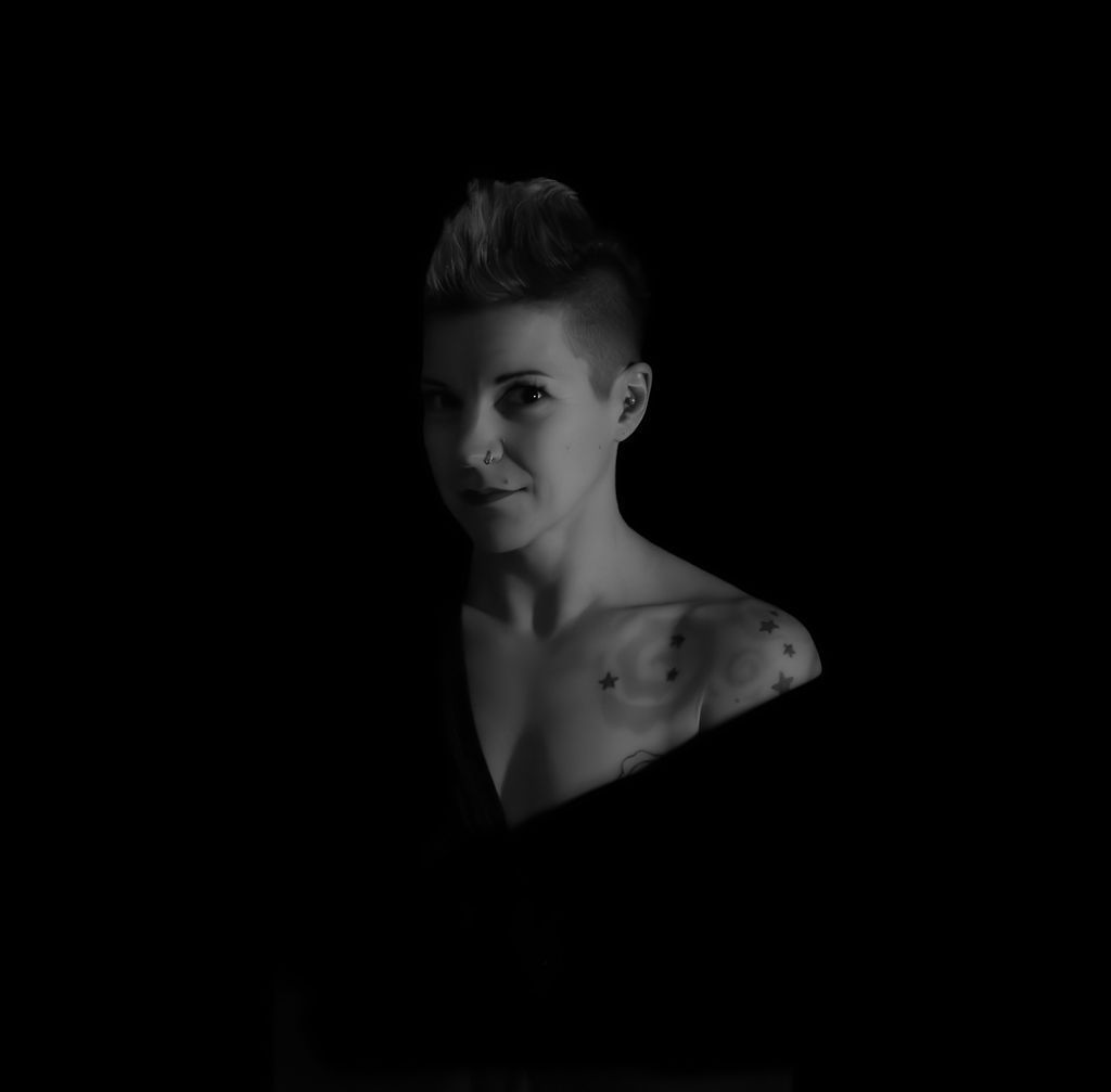 Black and white artistic portrait with dramatic shadows and lighting creating a moody atmosphere.
