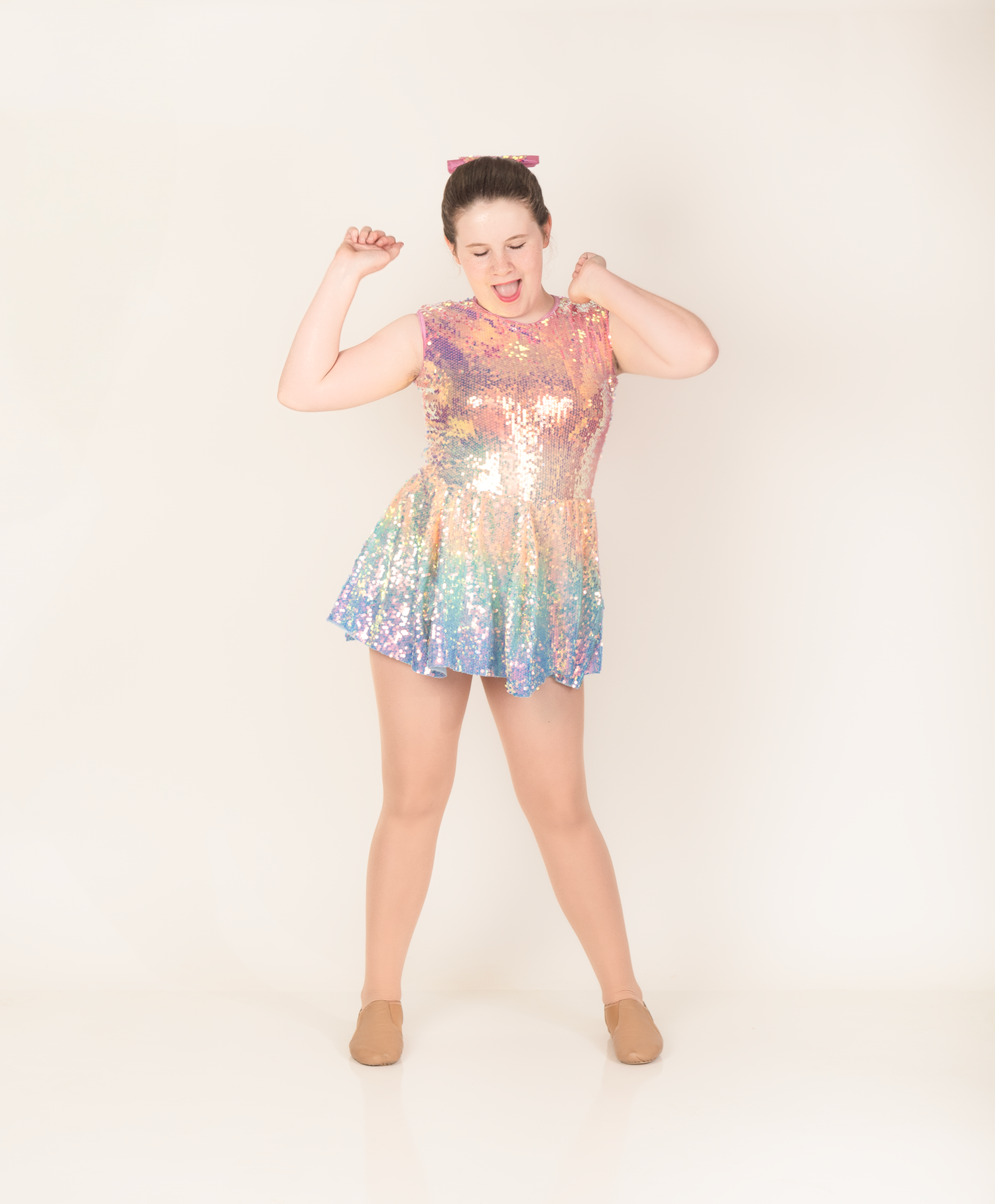 A dancer in a sparkly rainbow sequin dress strikes dynamic poses in a series of connected photos against a white backdrop.