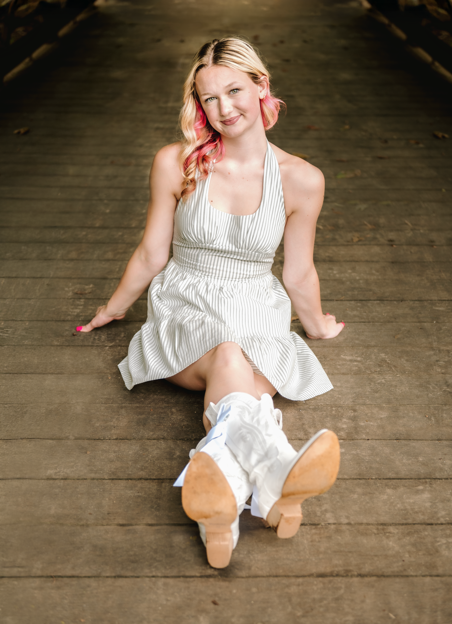 A series of candid portraits on a rustic wooden floor showing movement and playful poses in a white summer dress.