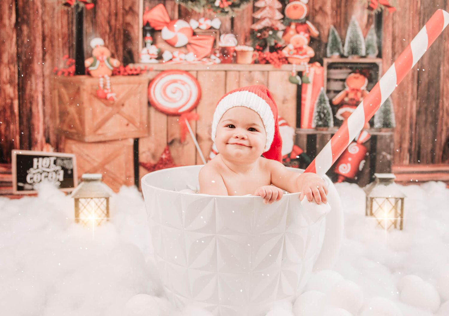 Holiday Christmas theme setup with cotton snow backdrop, glowing lanterns and festive red decorations.