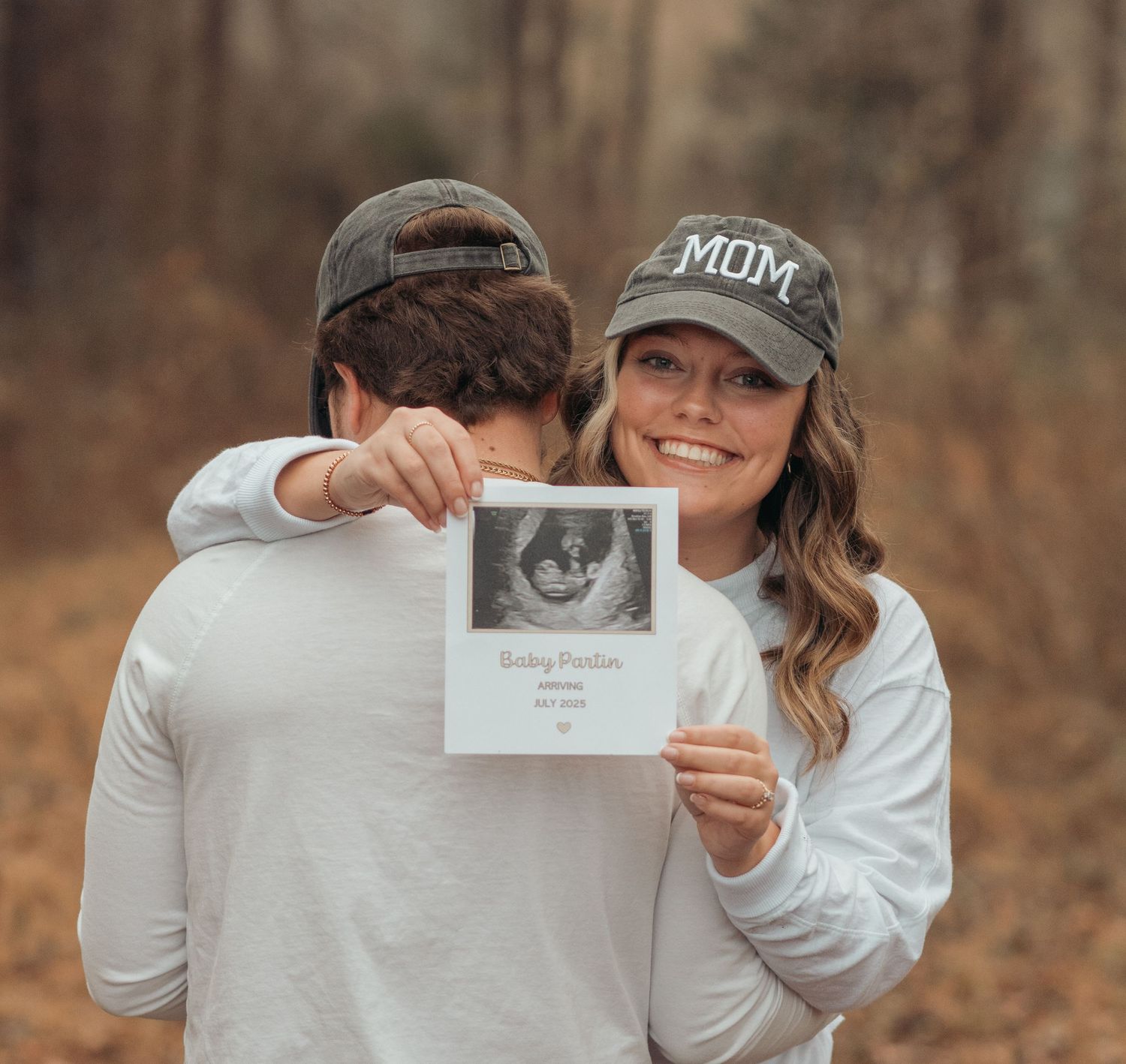 A pregnancy announcement scene showing an ultrasound photo in a fall setting taken by Krystie Nicole Photo in Smithfield, NC