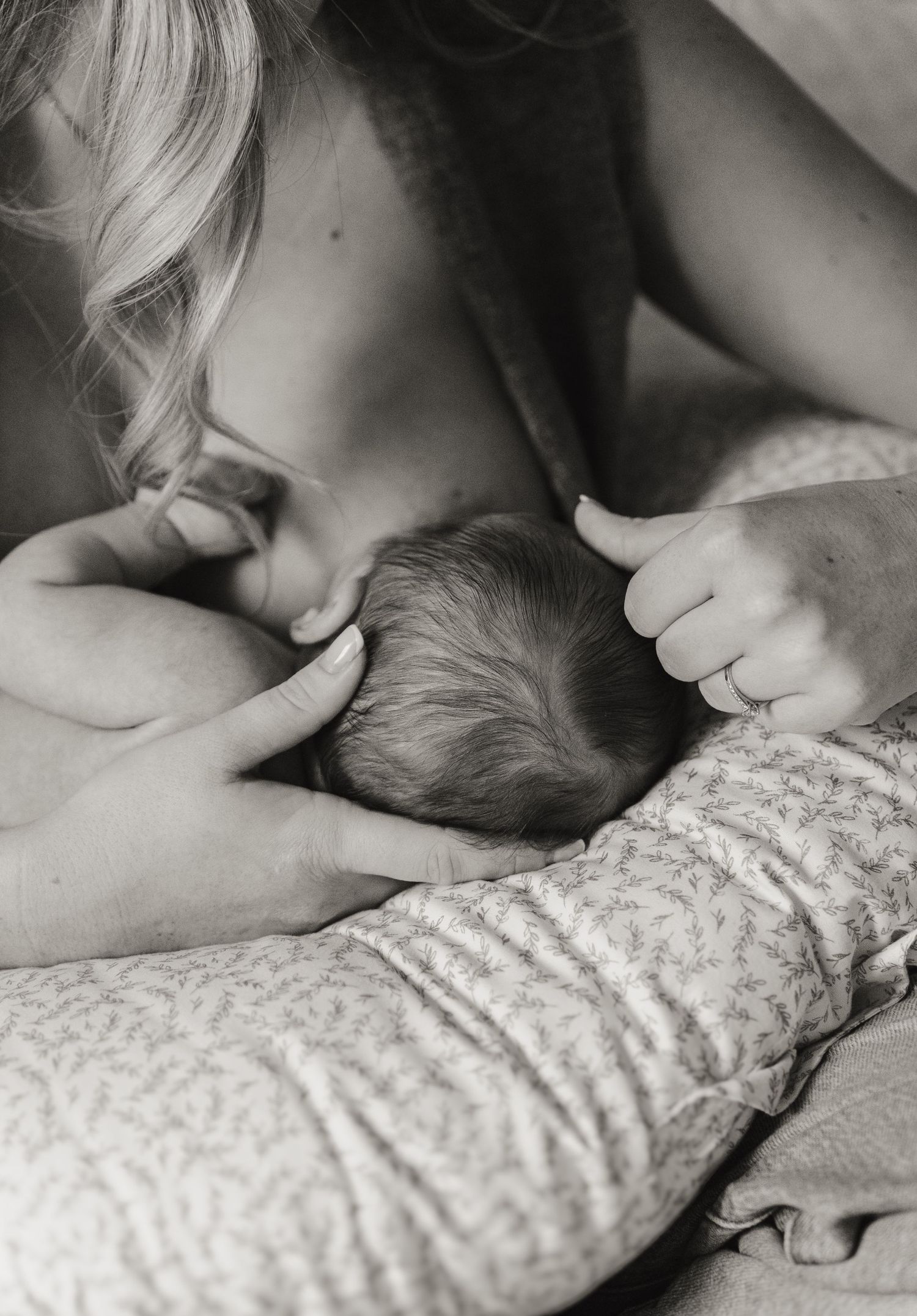 Black and white photo series showing tender moments of breastfeeding between parent and infant.