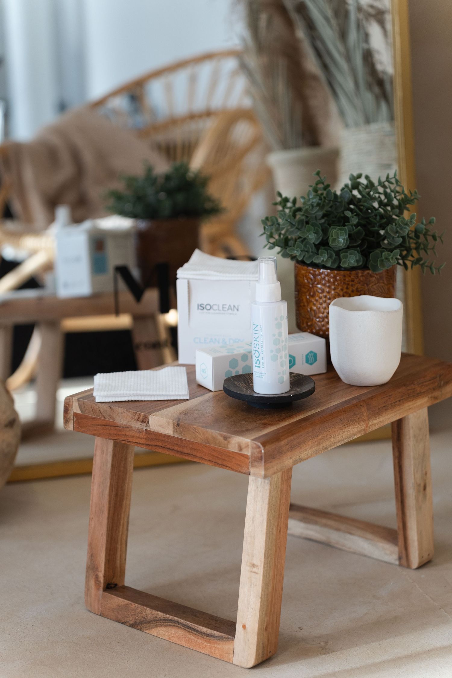 A wooden display stand with small white pots and decorative items arranged on its surface in a minimalist style.
