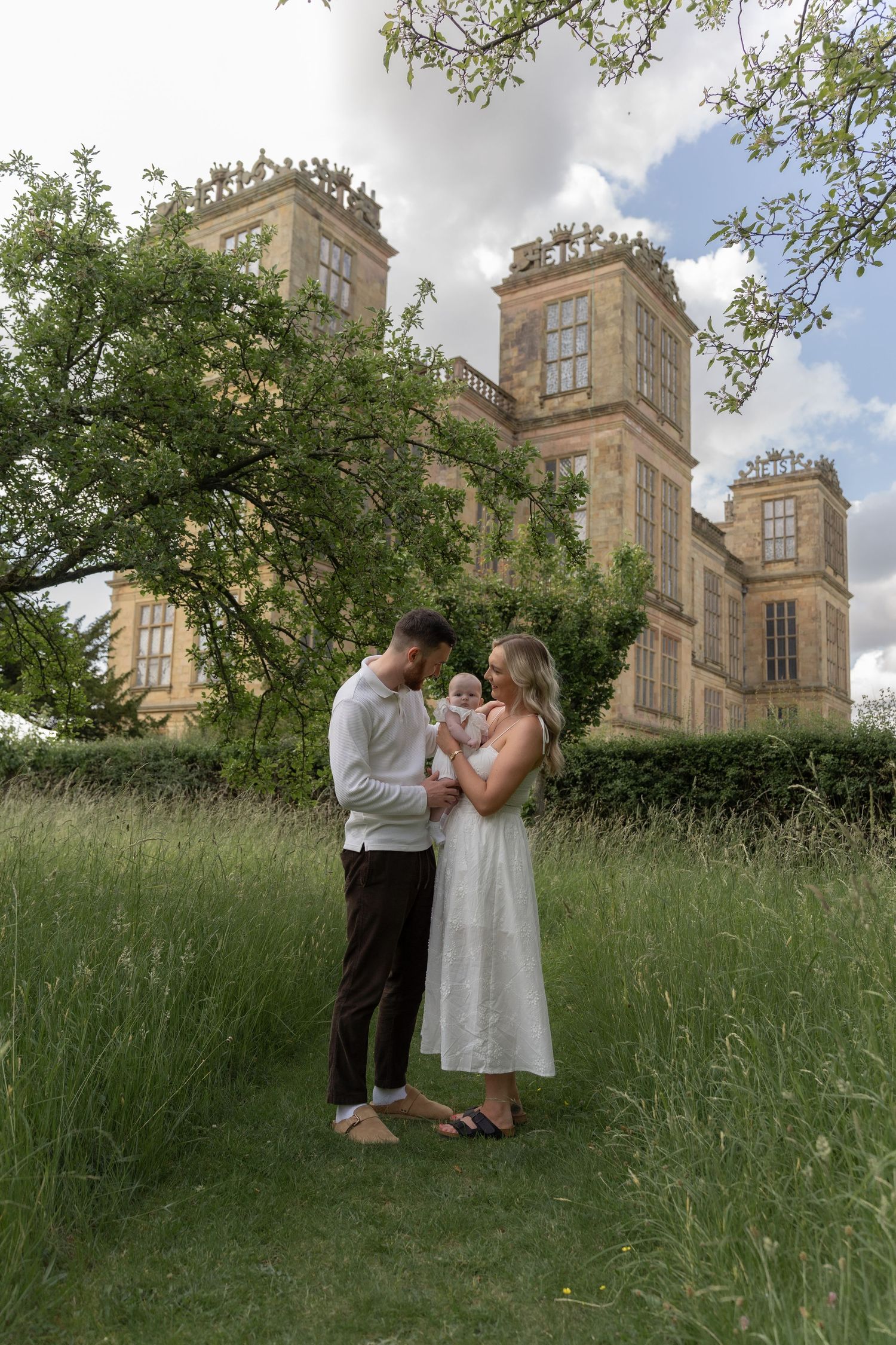 Romantic couple sharing sweet moments in front of a grand historic mansion.