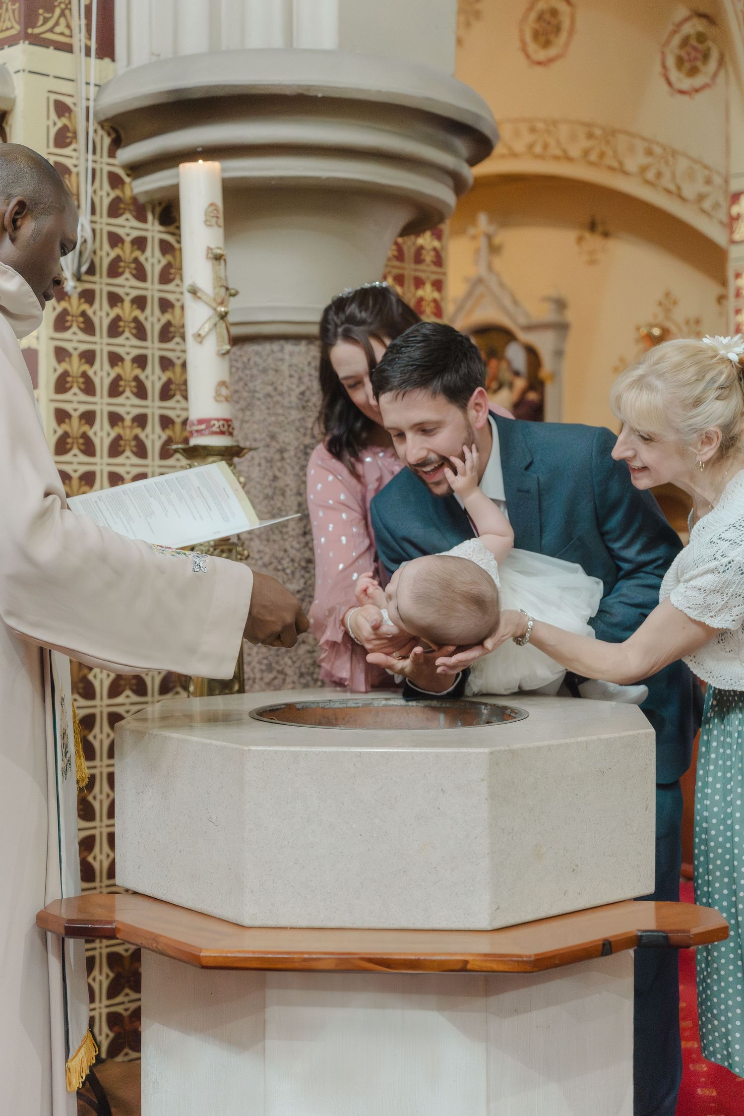 People gathered around an ornate stone basin in a vintage-styled interior with decorative columns.