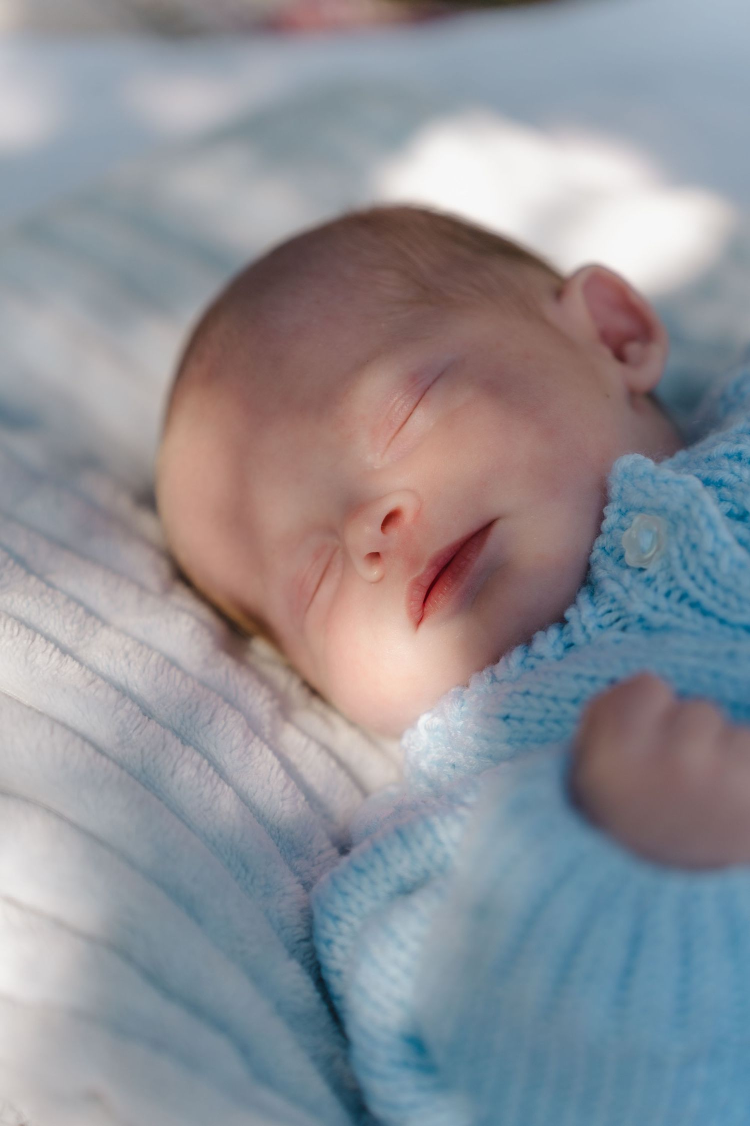 A sleeping baby in blue blankets photographed from different angles in a soft, dreamy style.