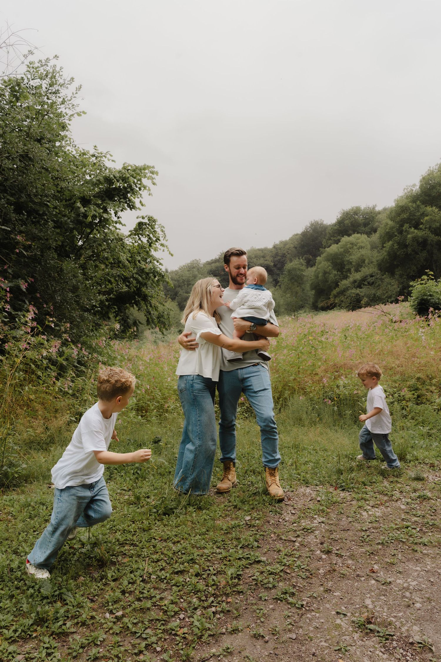 People playing and running together on a grassy hillside path.