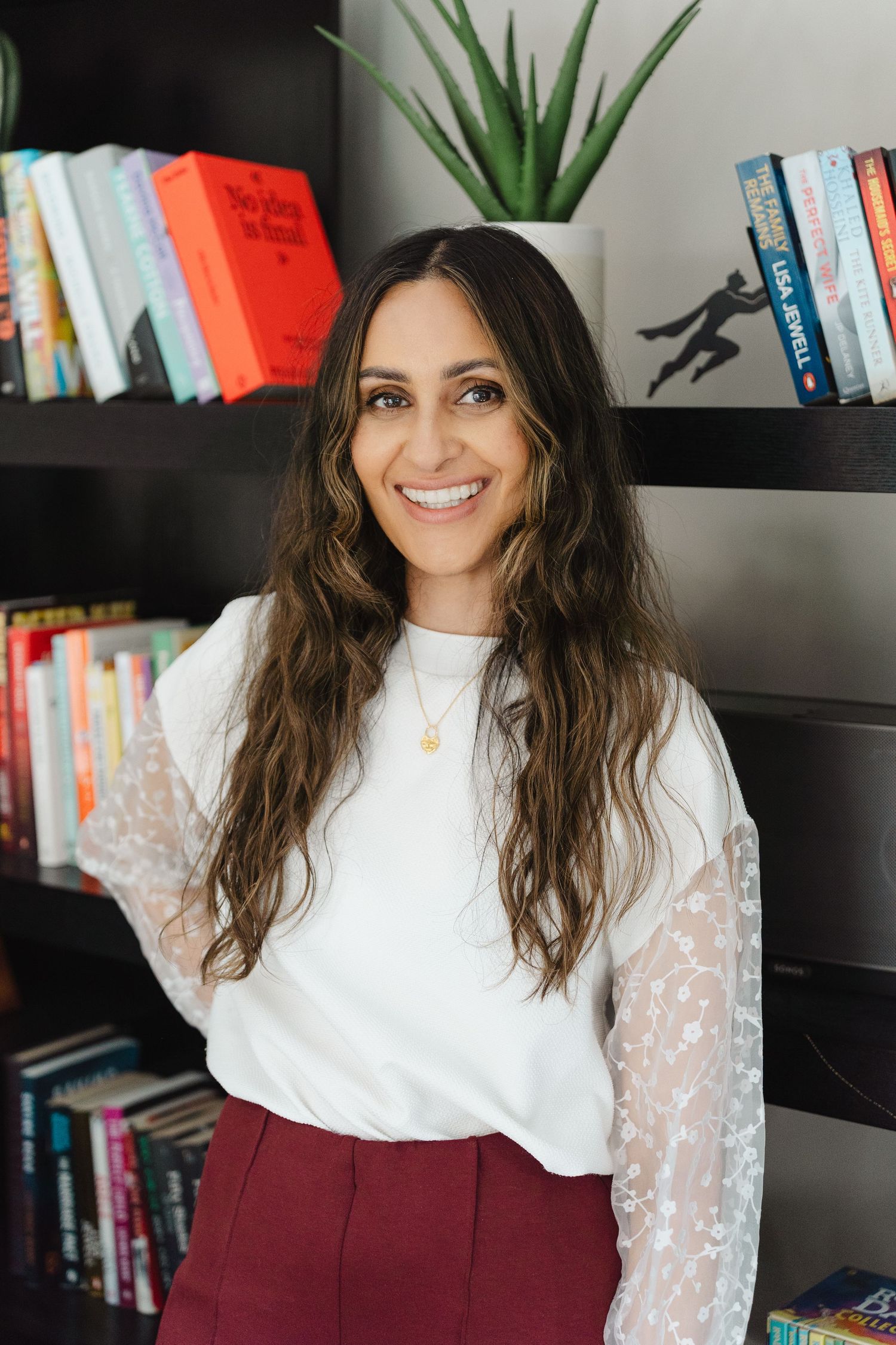 A series of photos showing someone in a white lace top and burgundy skirt posing against a bookshelf background.
