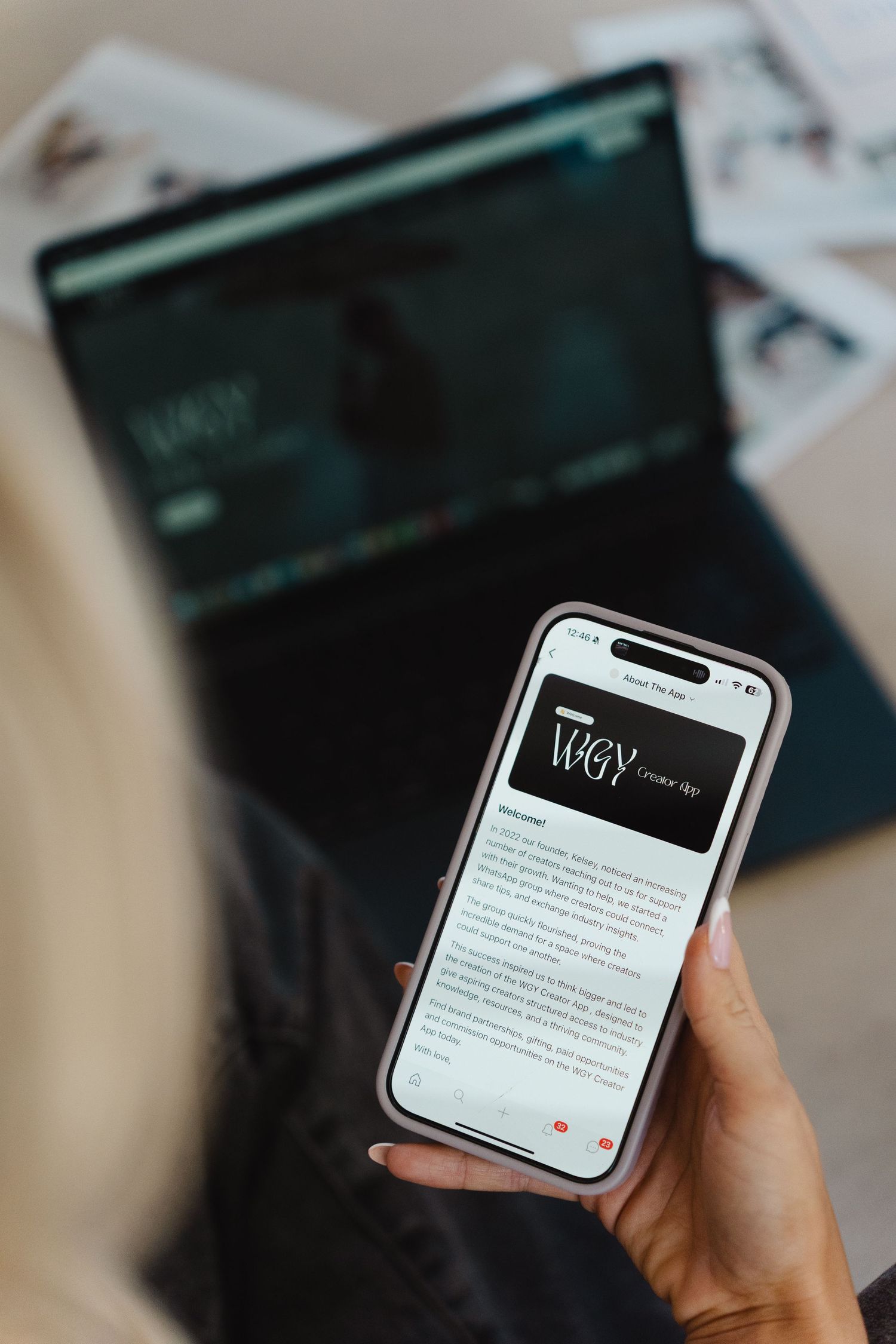 Hand holding white iPhone displaying text content on screen against dark background.