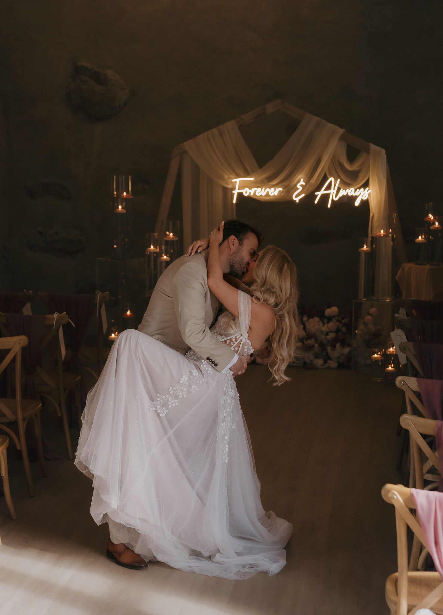 A romantic first dance sequence between newlyweds in a dimly lit reception venue with candlelight ambiance.