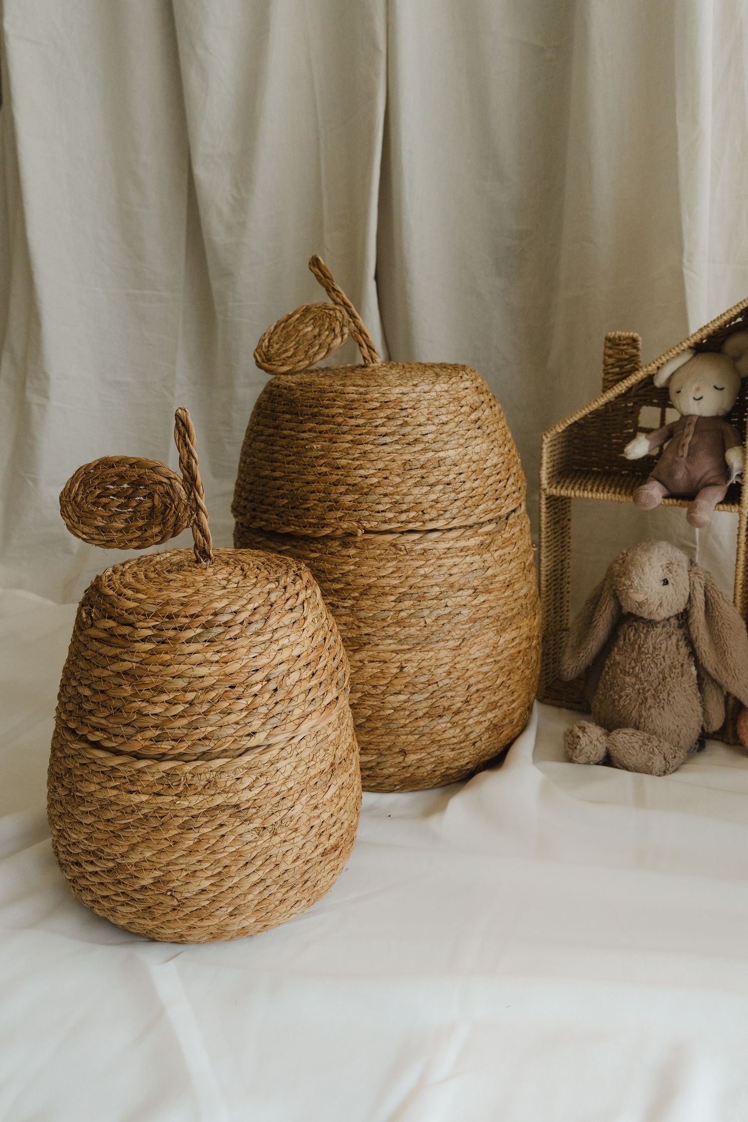 A sequence of five photos showing the progression of wrapping twine around a spherical base to create a decorative basket.