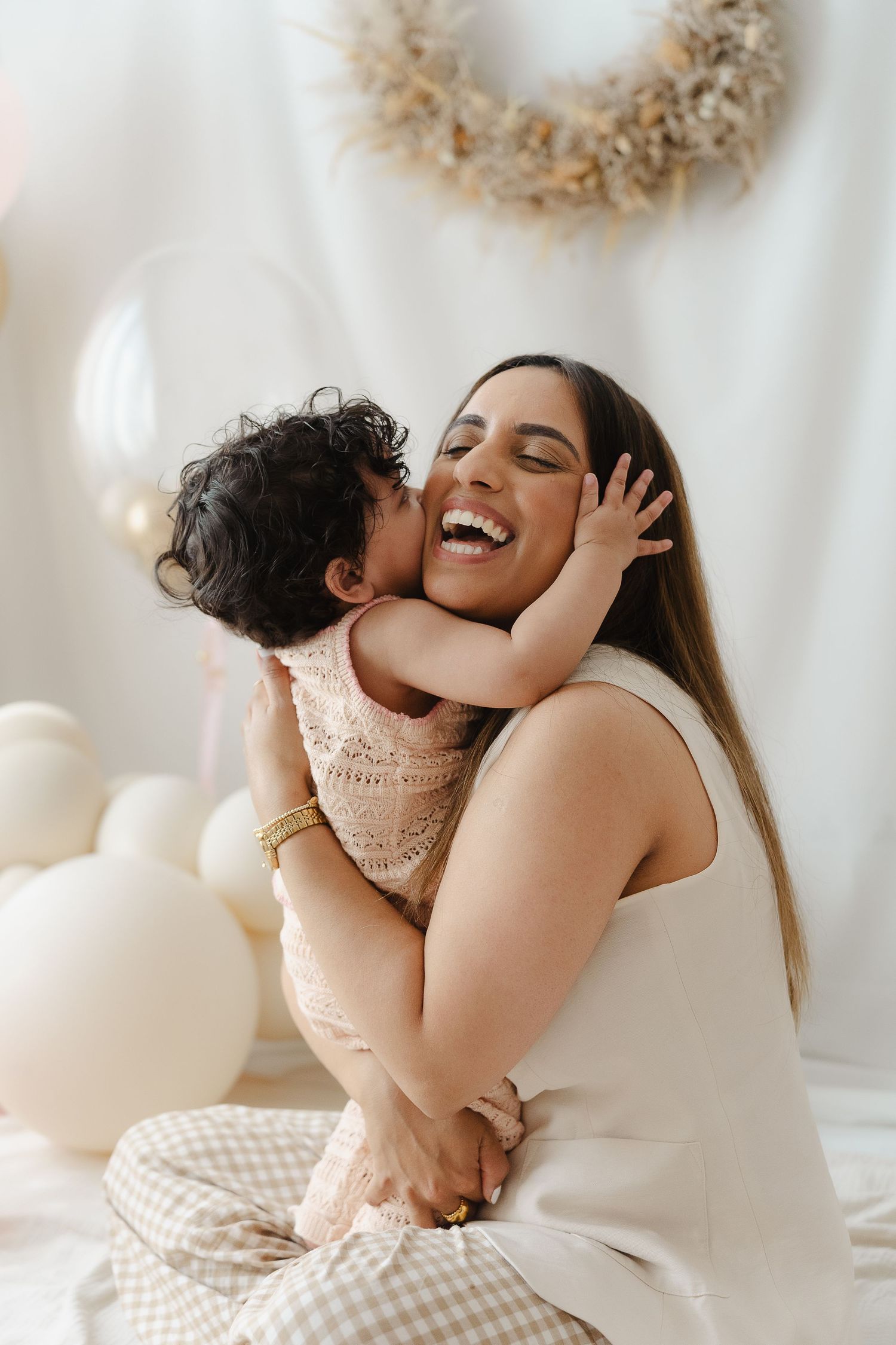 A tender moment captured in a series of white-toned lifestyle photos showing joyful embraces and genuine laughter.