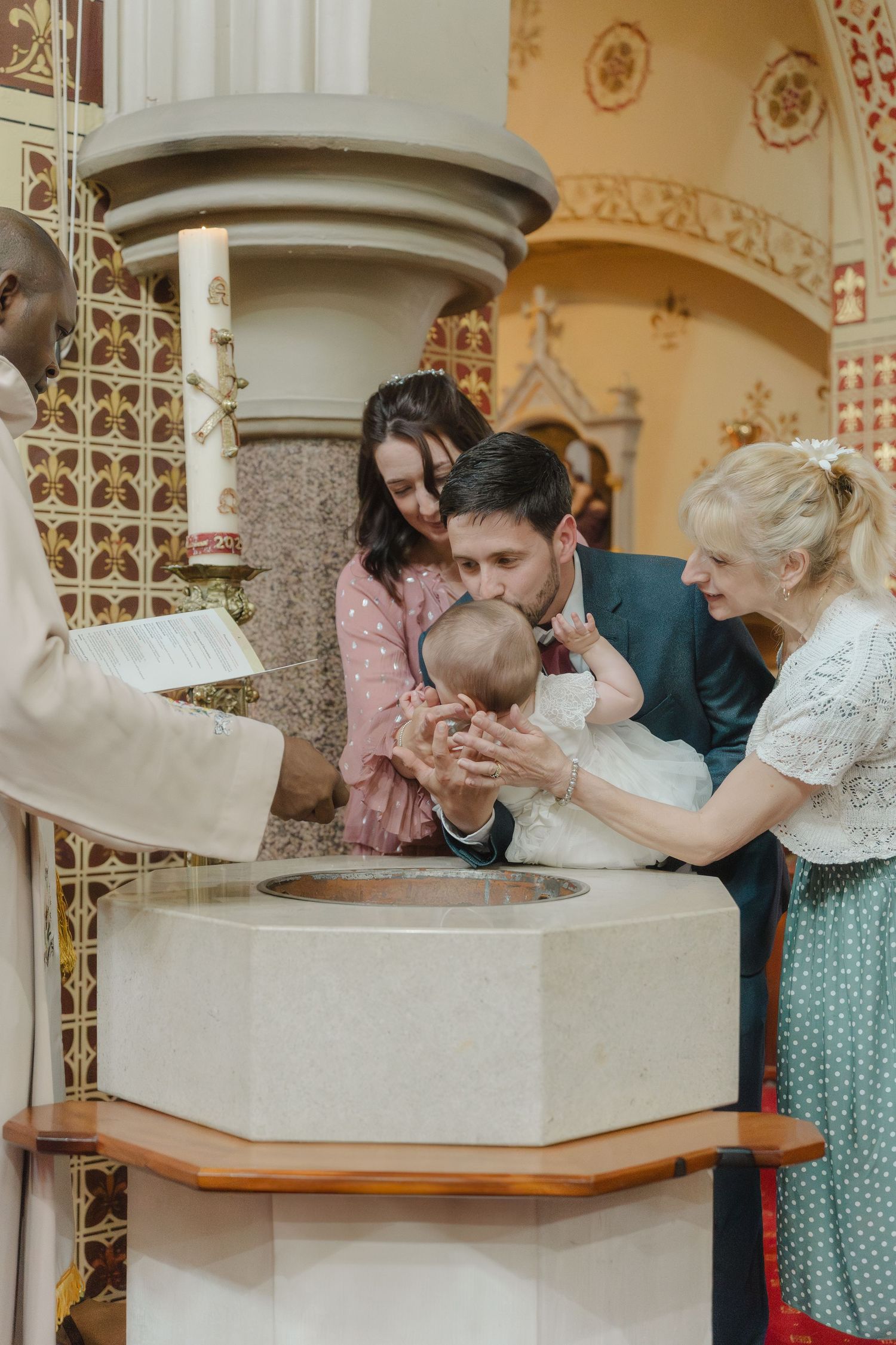 A group in vintage attire leans over a decorative fountain or basin in an ornate indoor setting.