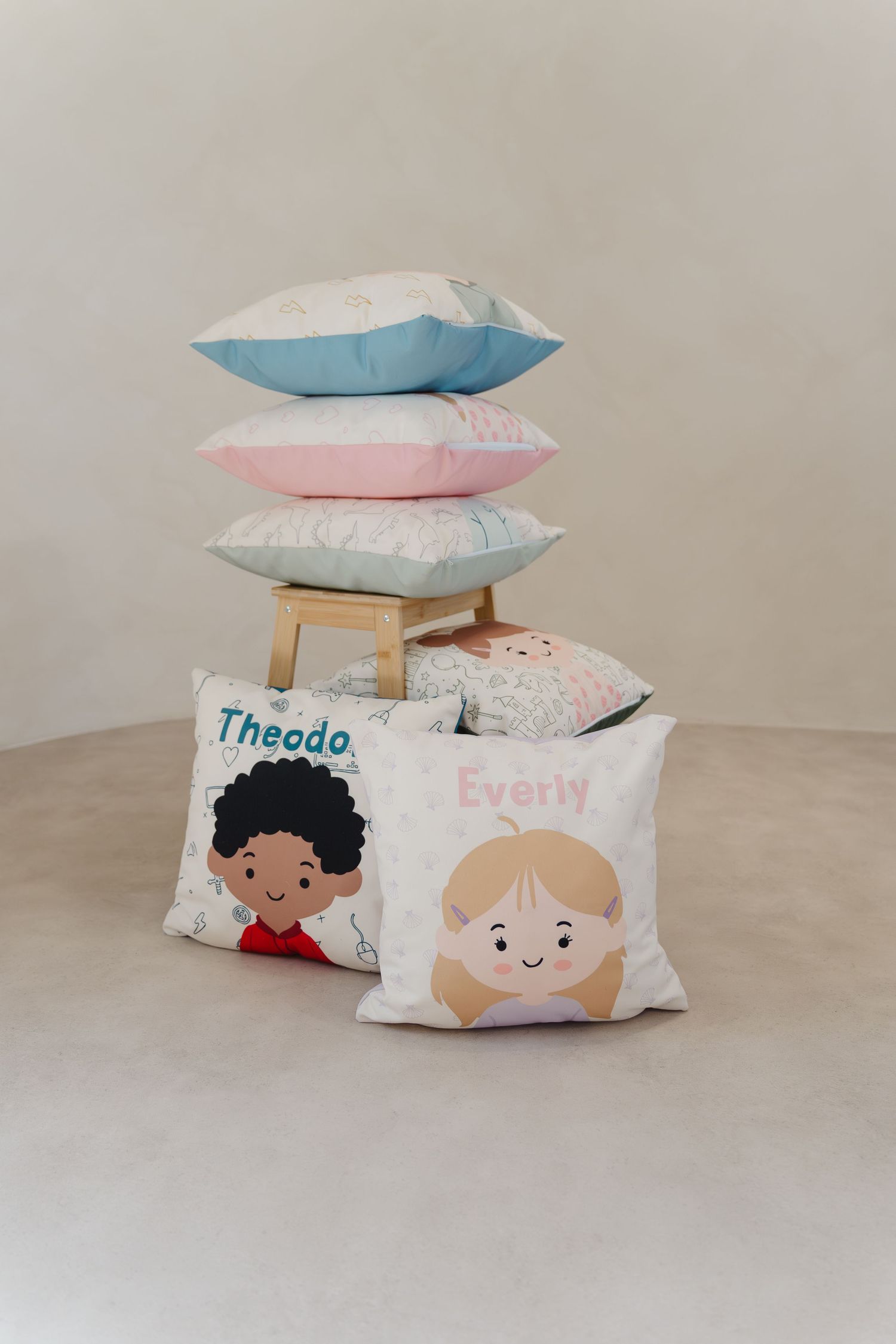 Decorative throw pillows with whimsical character designs stacked in various arrangements.