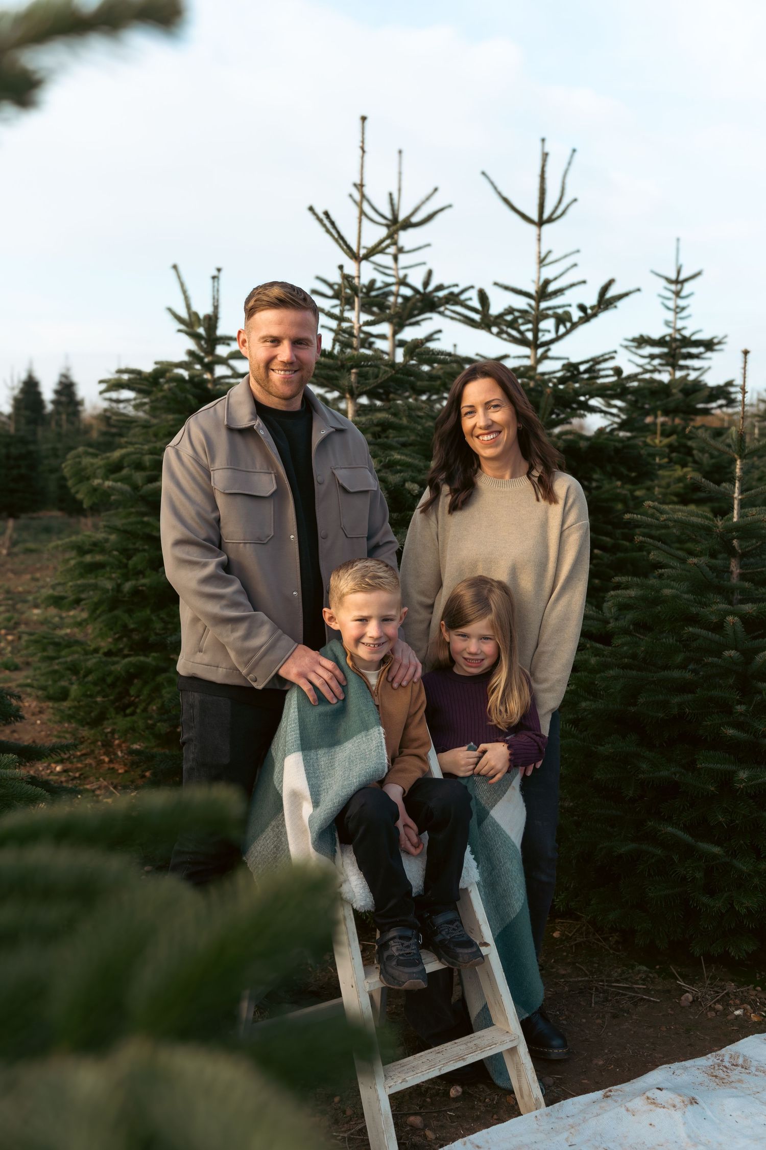 Family enjoying time together at a Christmas tree farm while selecting their perfect holiday tree.