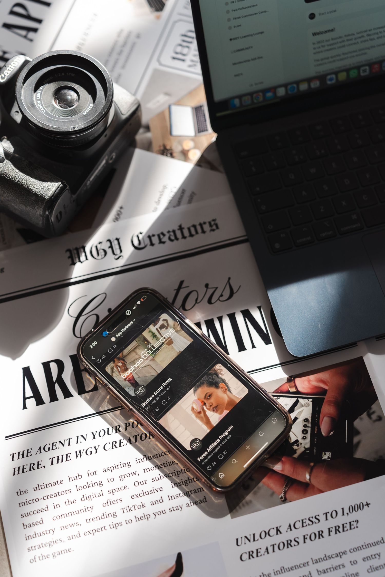 Flatlay of photography equipment and documents with text about creators and agents visible.