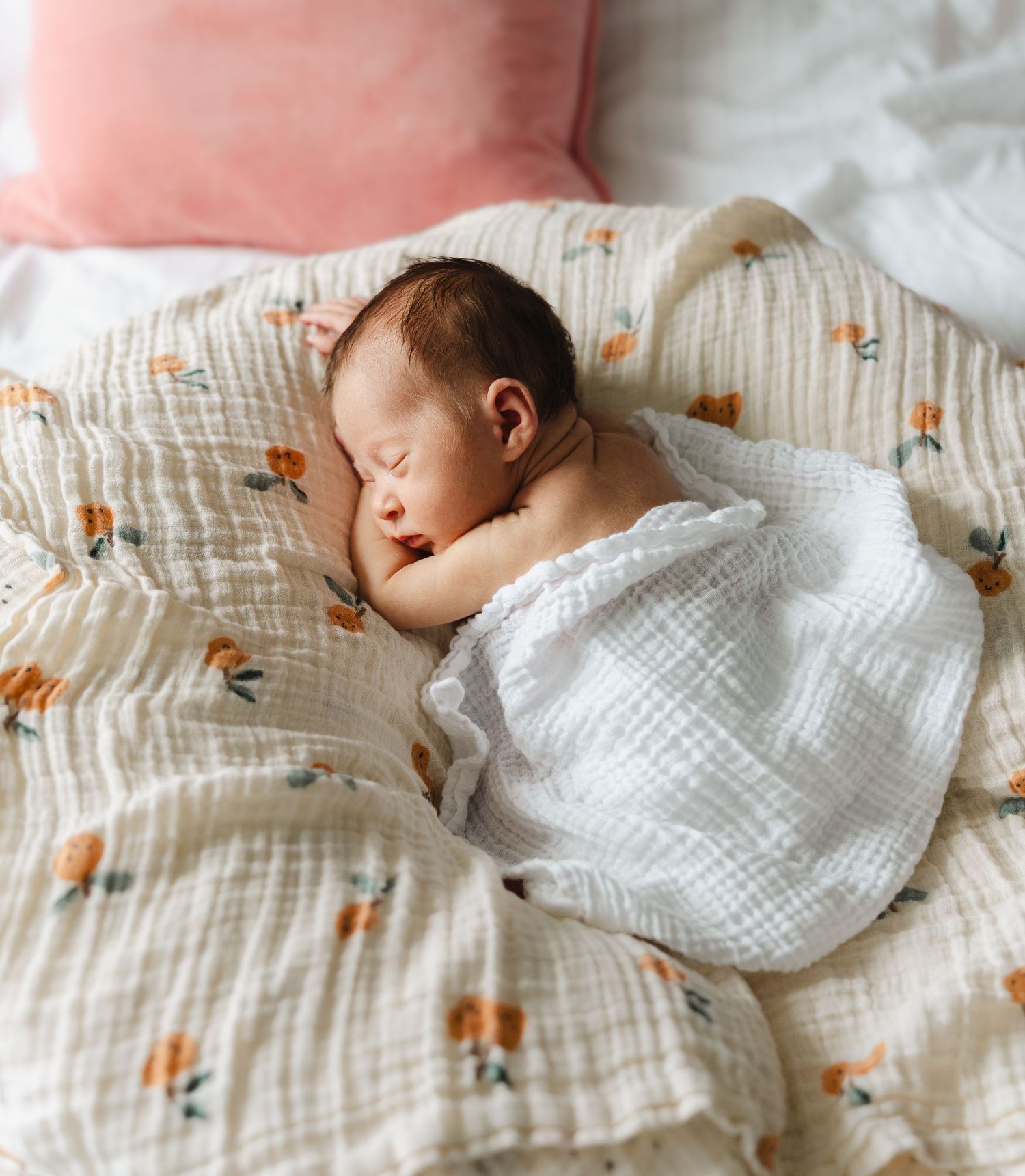 Baby sleeping peacefully on floral patterned bedding. Unposed newborn photography in Derby in-home shoot with Shots by Maz Photography.