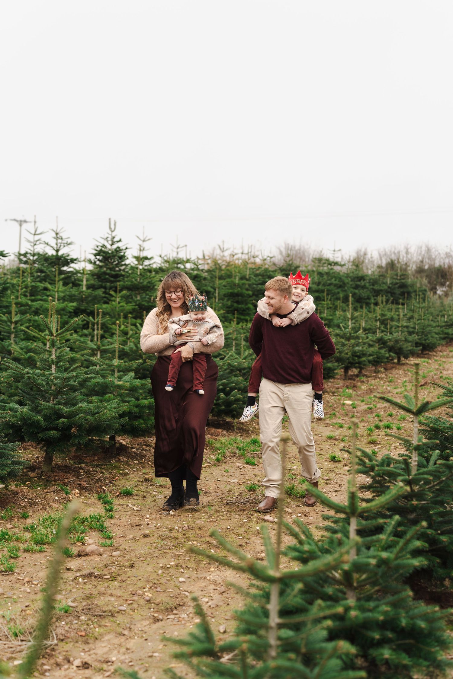 Family enjoying time together at a Christmas tree farm.