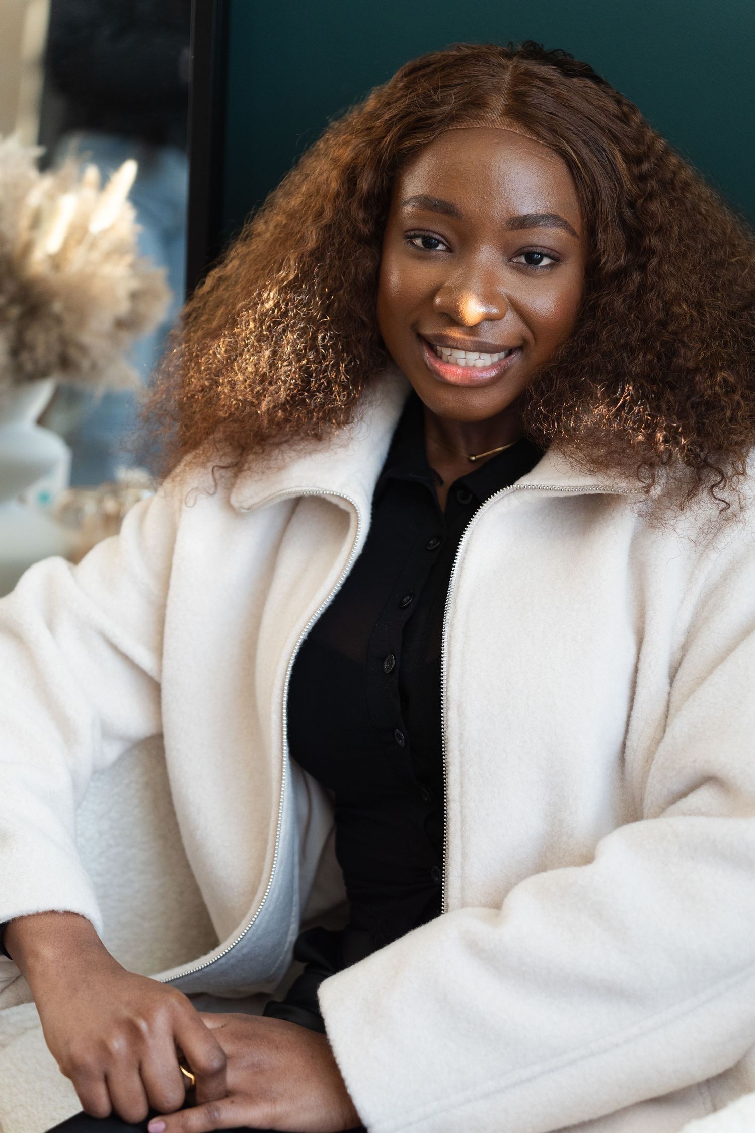 A person in a cozy white sweater poses against a dark background in a series of candid shots.
