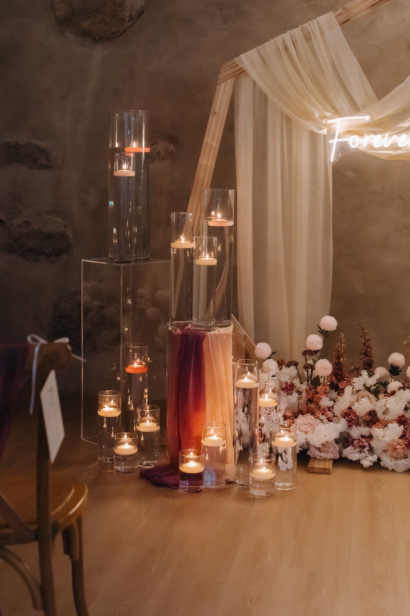 Romantic candlelit setup with white drapes and floral decorations creating intimate ambiance.