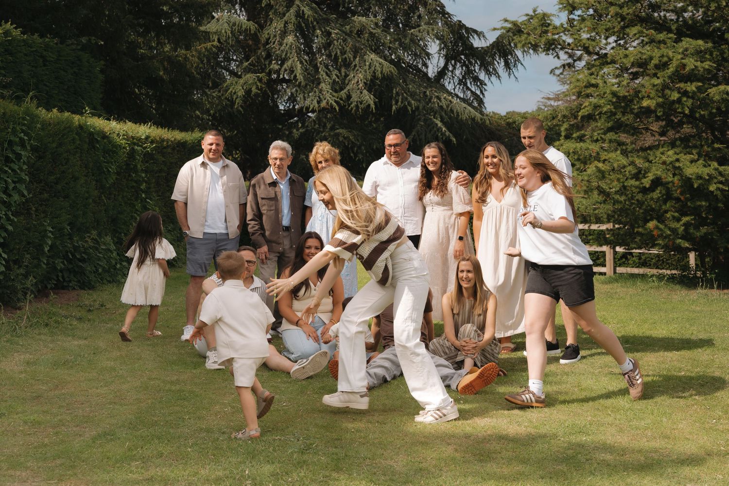 Generational photography in Derbyshire. Large family group laughing and playing together outdoors at Elvaston Castle.