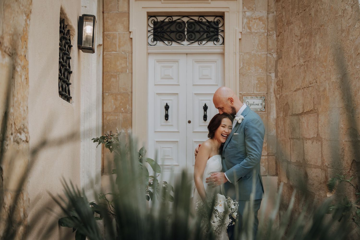 A beautiful stone building entrance with white doors and decorative iron details.