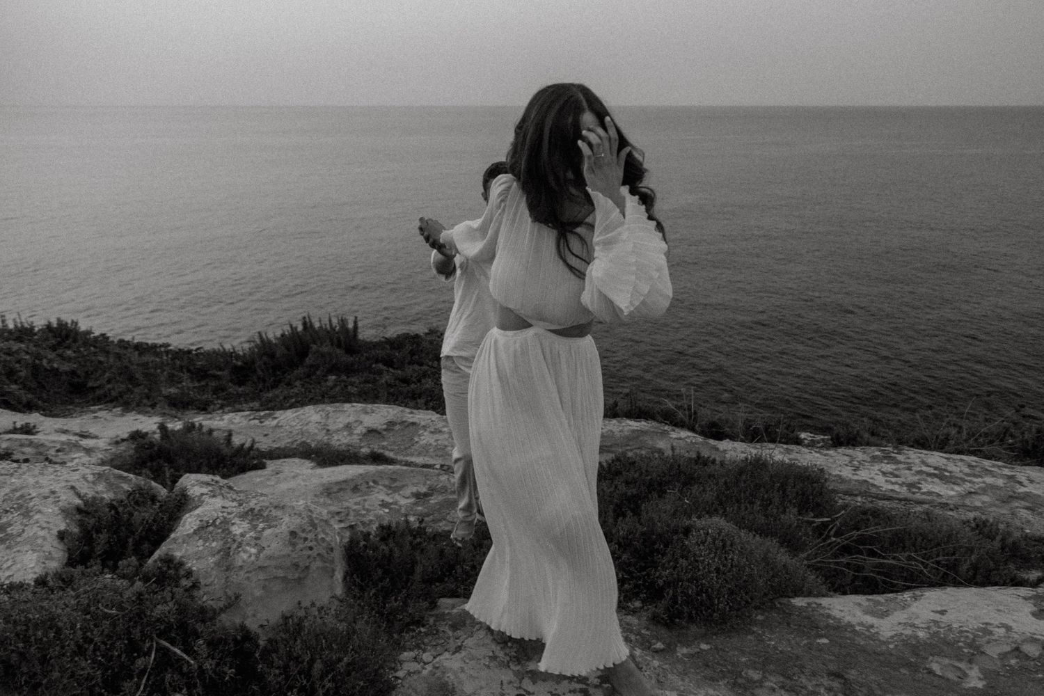 Dramatic black and white coastal portrait session with ocean views.